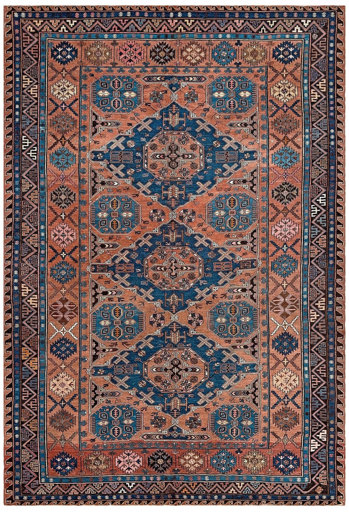 A traditional hand-knotted area rug with a geometric pattern, featuring a dusty terracotta center field, deep blue medallions, and a dark brown border. Late 19th century antique Konagkend Soumak rug from Kuba, Caucasus – 8x10 tribal flatweave with indigo, terracotta, and copper brown tones, available at the best rug shop in SF Bay Area.