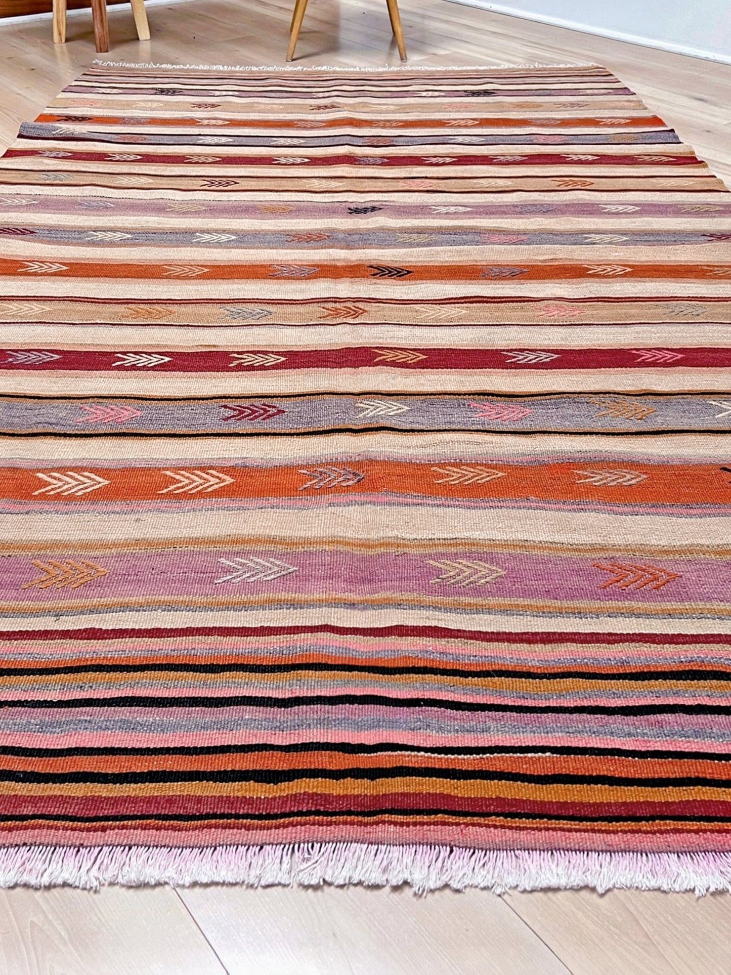 Vintage Anatolian kilim rug, 6x8 with horizontal arrow motifs in sun-washed tones.