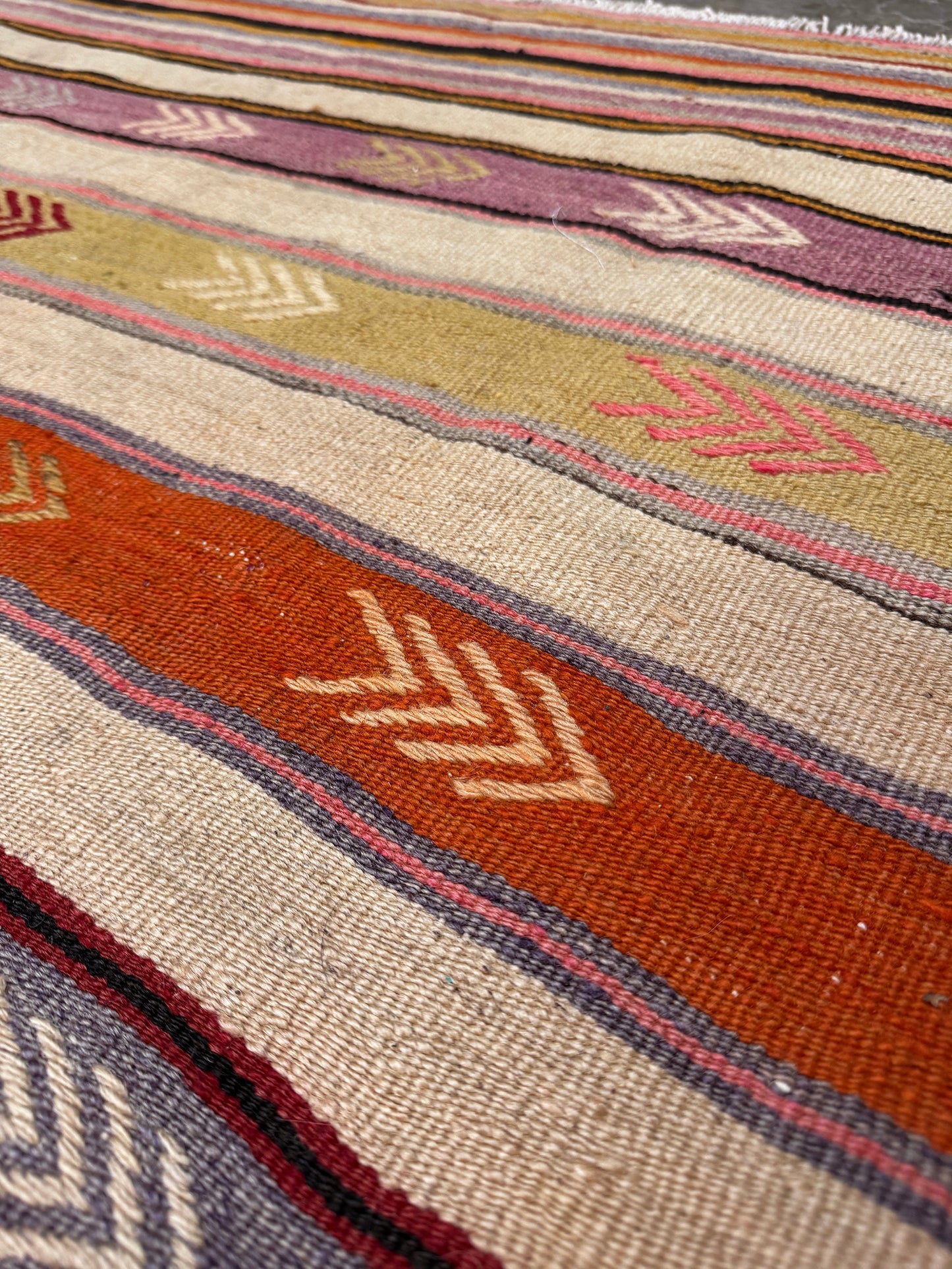 Vintage Anatolian kilim rug, 6x8 with horizontal arrow motifs in sun-washed tones.