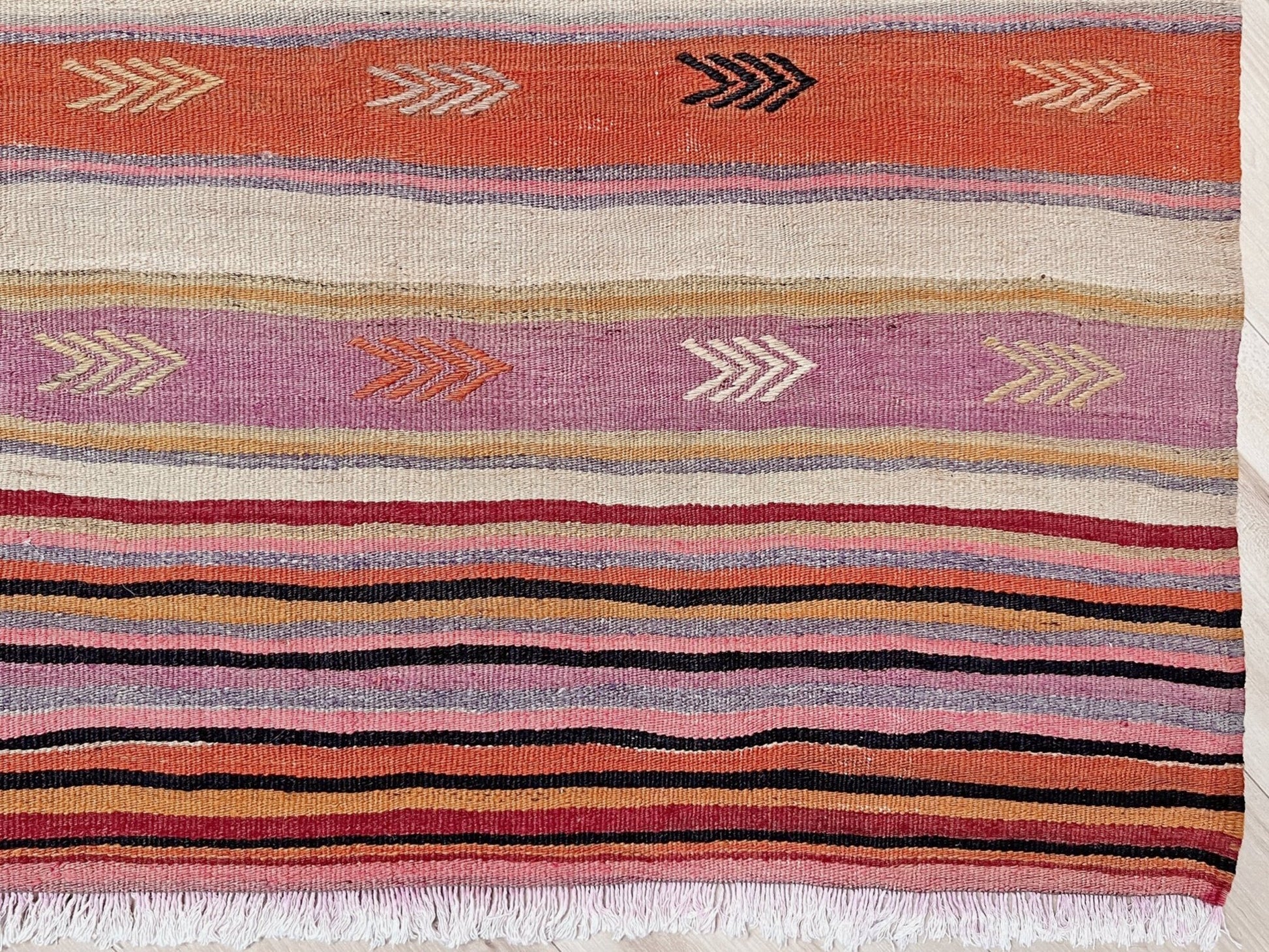 Vintage Anatolian kilim rug, 6x8 with horizontal arrow motifs in sun-washed tones.