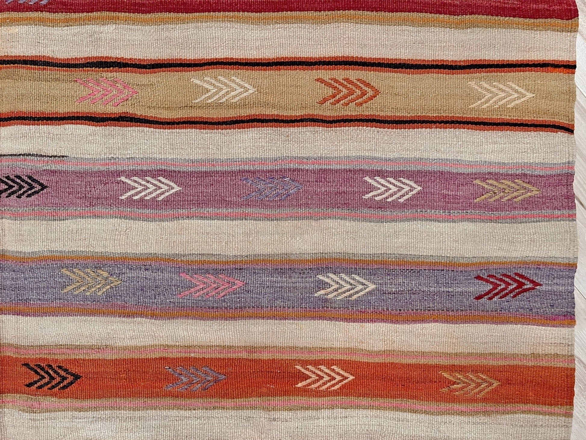 Vintage Anatolian kilim rug, 6x8 with horizontal arrow motifs in sun-washed tones.