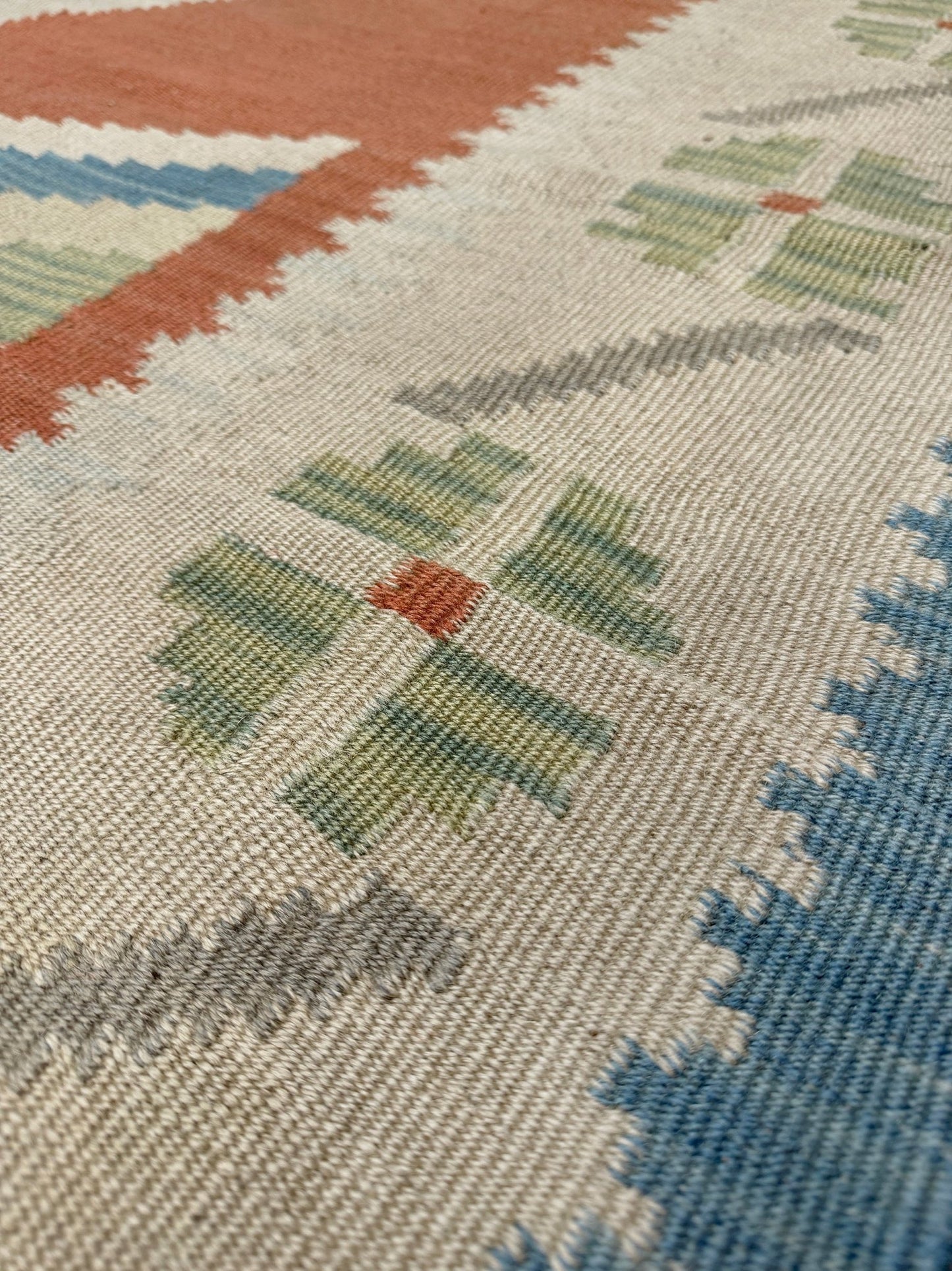 Close-up of a patterned rug with geometric design. Vintage Turkish Malatya kilim rug with coral red field and diamond medallions, handwoven Anatolian flatweave 5x8 geometric wool rug
