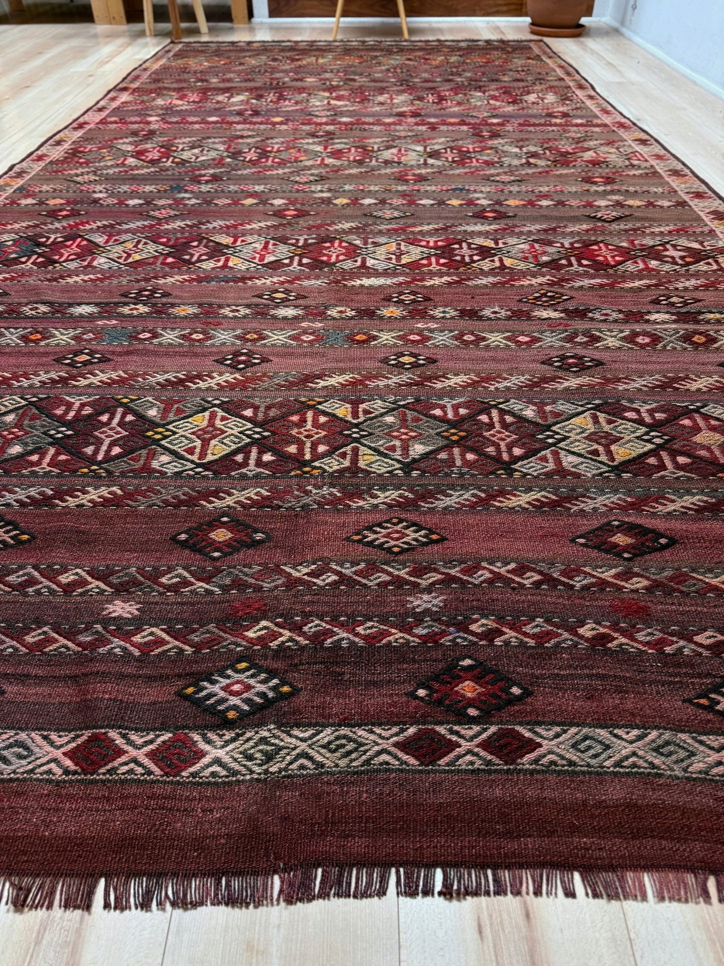 7x13 eggplant purple oxblood red Vintage 1940s Kurdish Kars kilim rug with tribal motifs. Handmade wool flatweave rug — perfect for long living rooms, hallways, great rooms, and layered interiors. From Indigo Rugs, Burlingame CA. Free shipping.