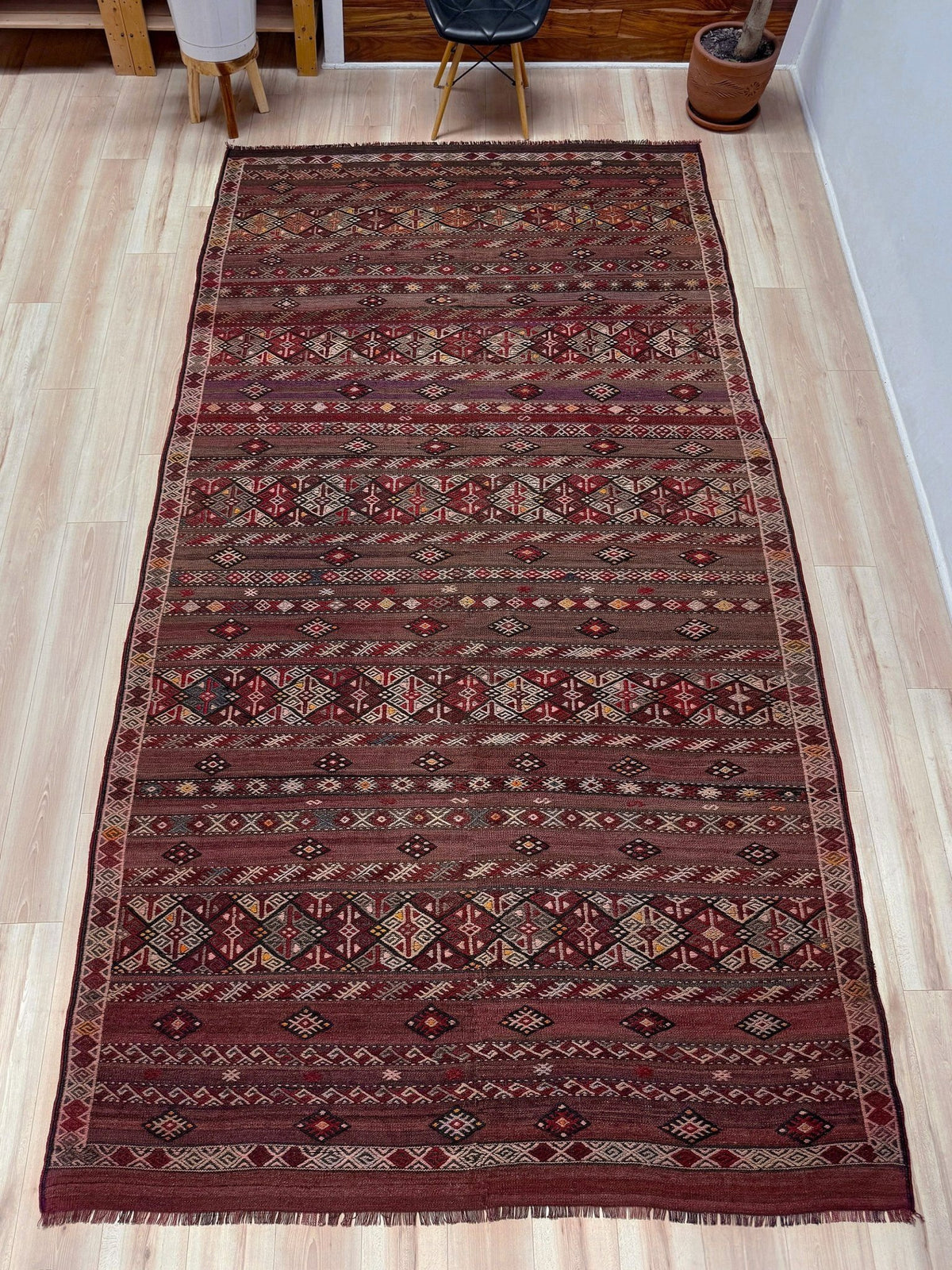 Traditional patterned rug with geometric design. 7x13 eggplant purple oxblood red Vintage 1940s Kurdish Kars kilim rug with tribal motifs for long living rooms, hallways, great rooms, and layered interiors. From Indigo Rugs, Burlingame CA.