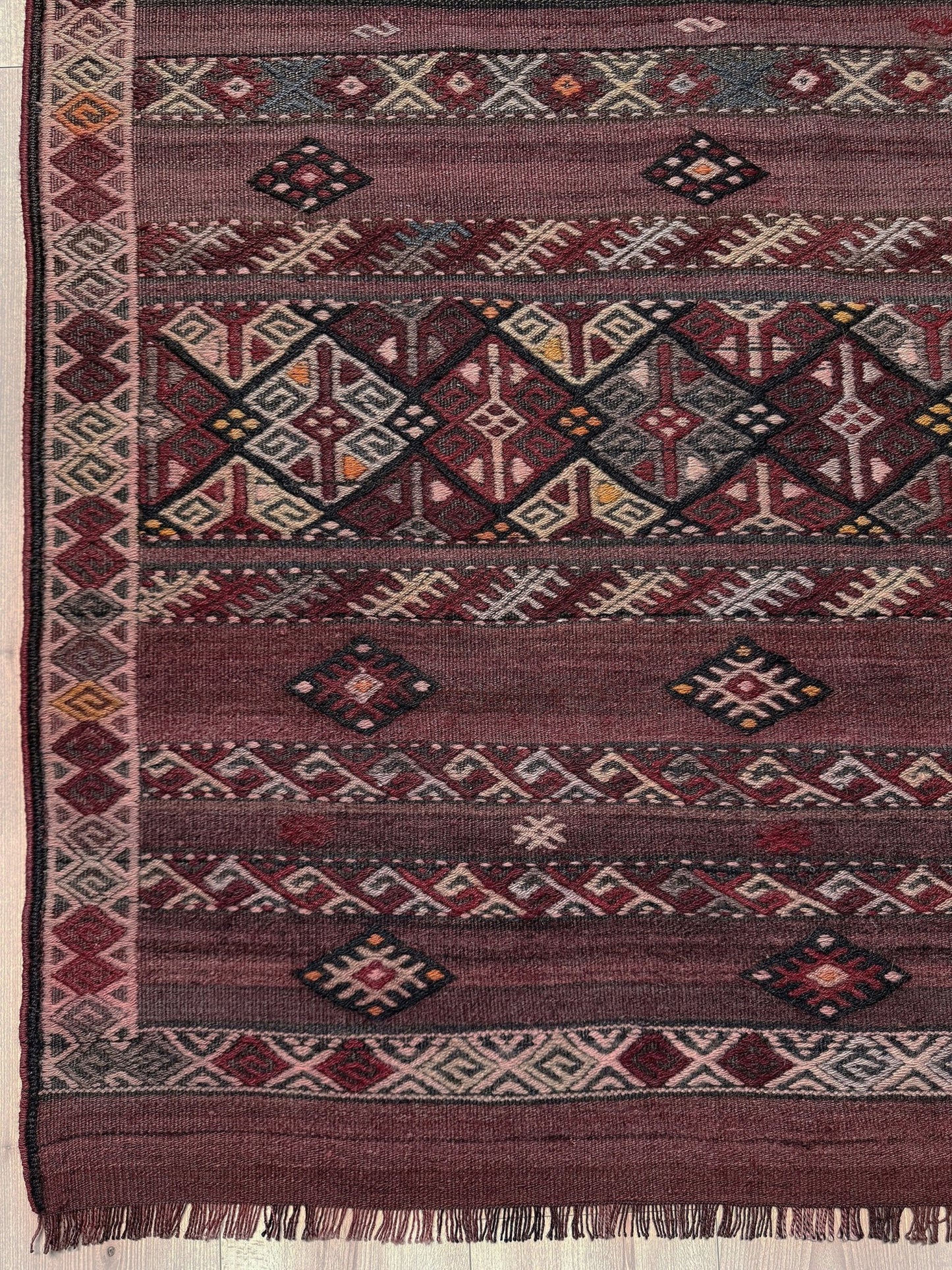 Traditional patterned rug with geometric design. 7x13 eggplant purple oxblood red Vintage 1940s Kurdish Kars kilim rug with tribal motifs for long living rooms, hallways, great rooms, and layered interiors. From Indigo Rugs, Burlingame CA.