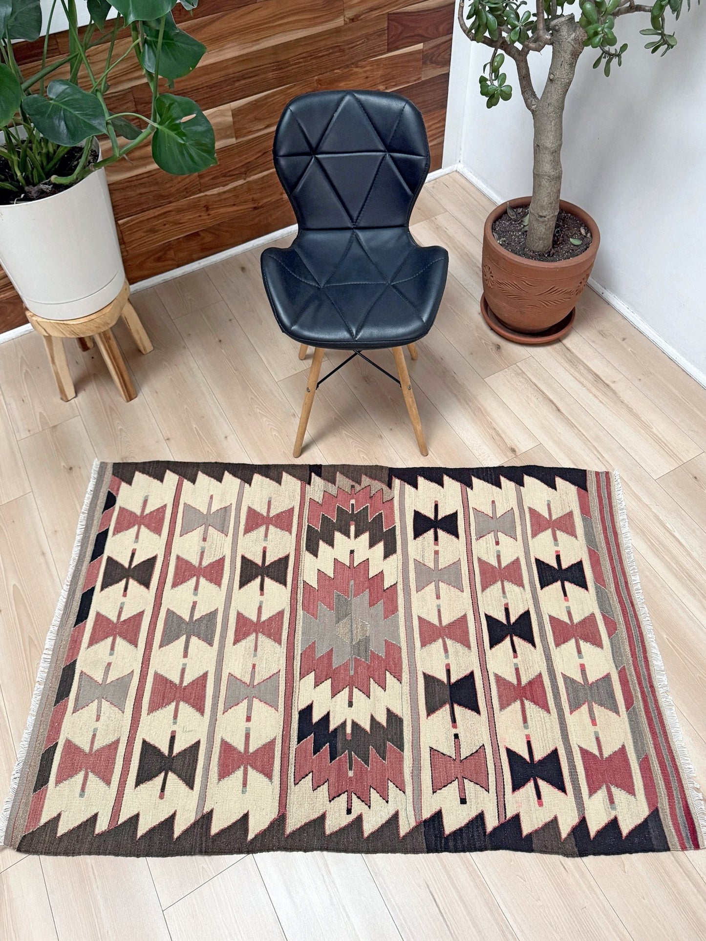 Vintage Mut Turkish kilim (3′1″ × 4′10″) with bow-tie tribal motifs and a stepped medallion in warm ivory, muted rose, taupe-grey, chocolate brown. Handmade Turkish flatweave, 1970s, sold by Indigo Rugs in Burlingame / San Francisco Bay Area.