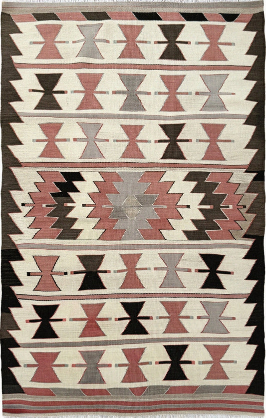 Vintage Mut Turkish kilim (3′1″ × 4′10″) with bow-tie tribal motifs and a stepped medallion in warm ivory, muted rose, taupe-grey, chocolate brown. Handmade Turkish flatweave, 1970s, sold by Indigo Rugs in Burlingame / San Francisco Bay Area.