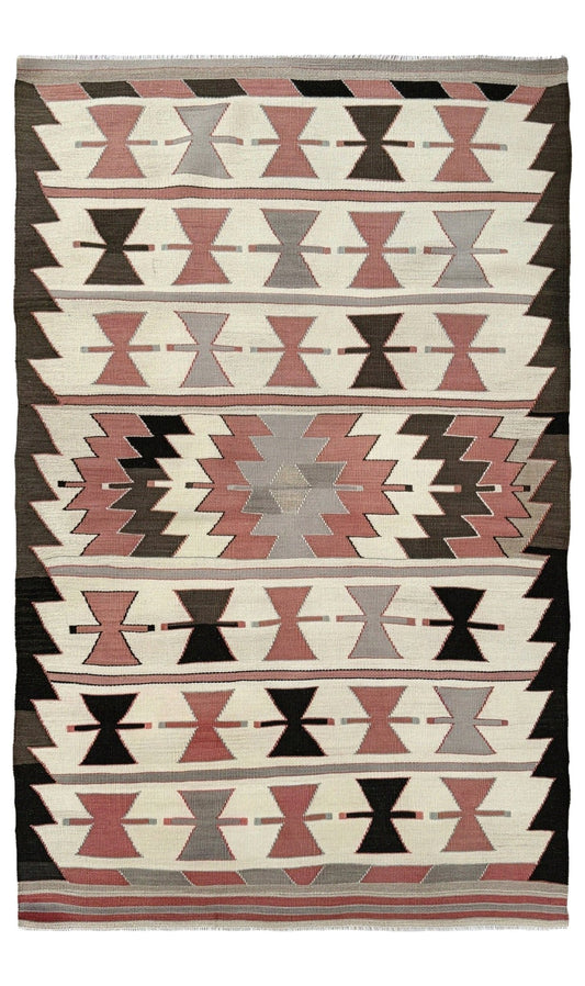 Woven textile with geometric pattern featuring black, pink, and gray on a white background. Vintage Mut Turkish kilim 3x5 with bow-tie tribal motifs and a stepped medallion Handmade Turkish flatweave, 1970s, sold by Indigo Rugs in Burlingame / San Francisco Bay Area.