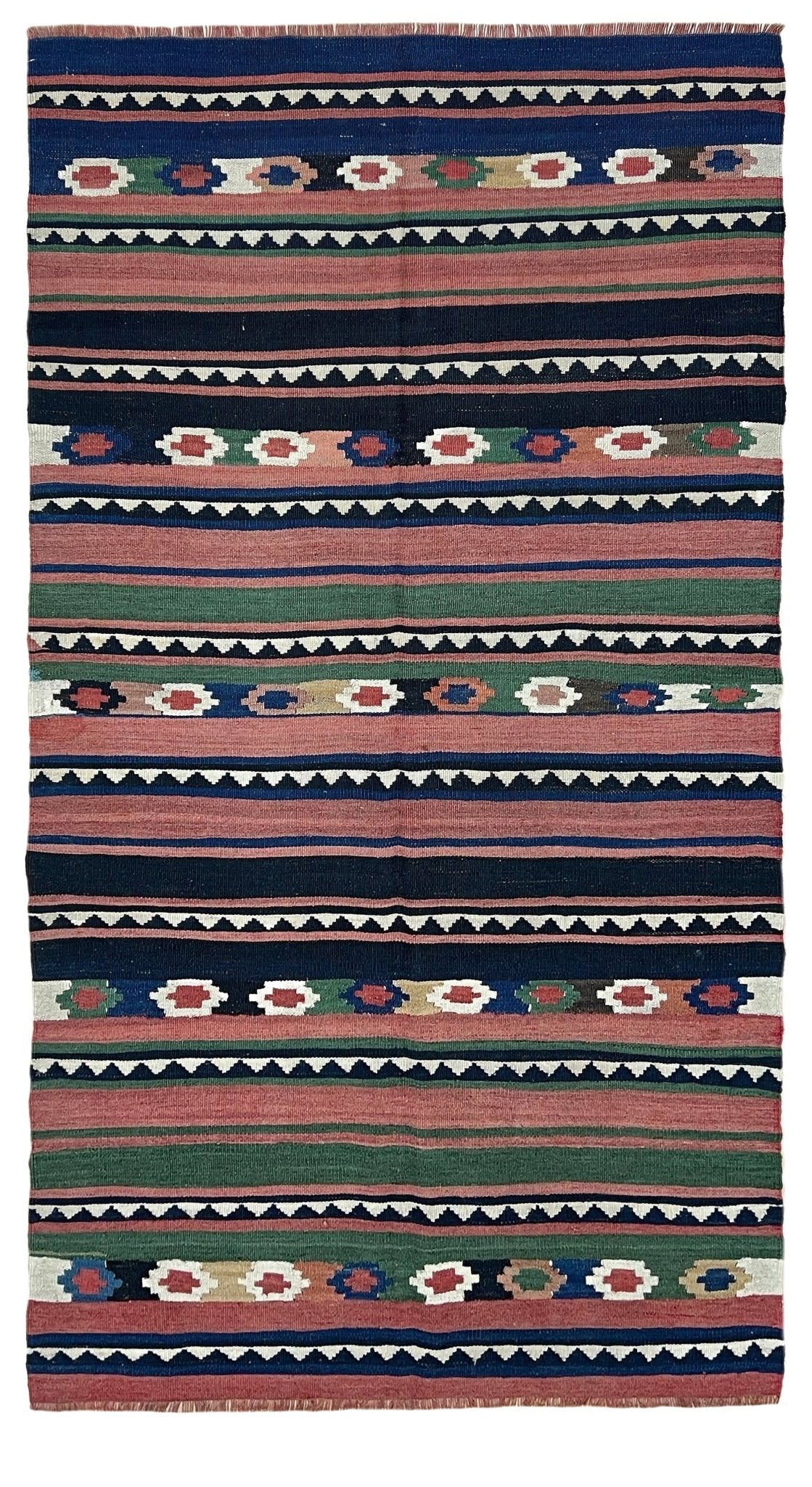 A flat-laid kilim rug with horizontal bands of geometric and floral patterns in navy blue, terracotta red, sage green, cream, and black.