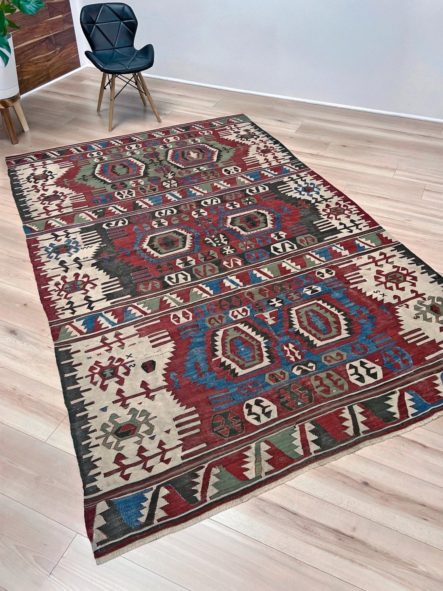 Decorative rug with geometric pattern on a wooden floor. Antique konya turkish kilim rug 6x9 vintage tribal geometric flatweave 1930s distressed handmade anatolian wool rug san francisco bay area rug shop indigo rugs