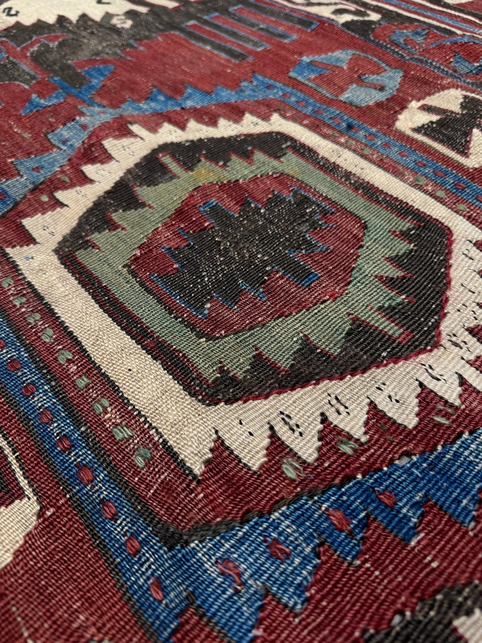 Close-up of a patterned rug with geometric design. Antique konya turkish kilim rug 6x9 vintage tribal geometric flatweave 1930s distressed handmade anatolian wool rug san francisco bay area rug shop indigo rugs