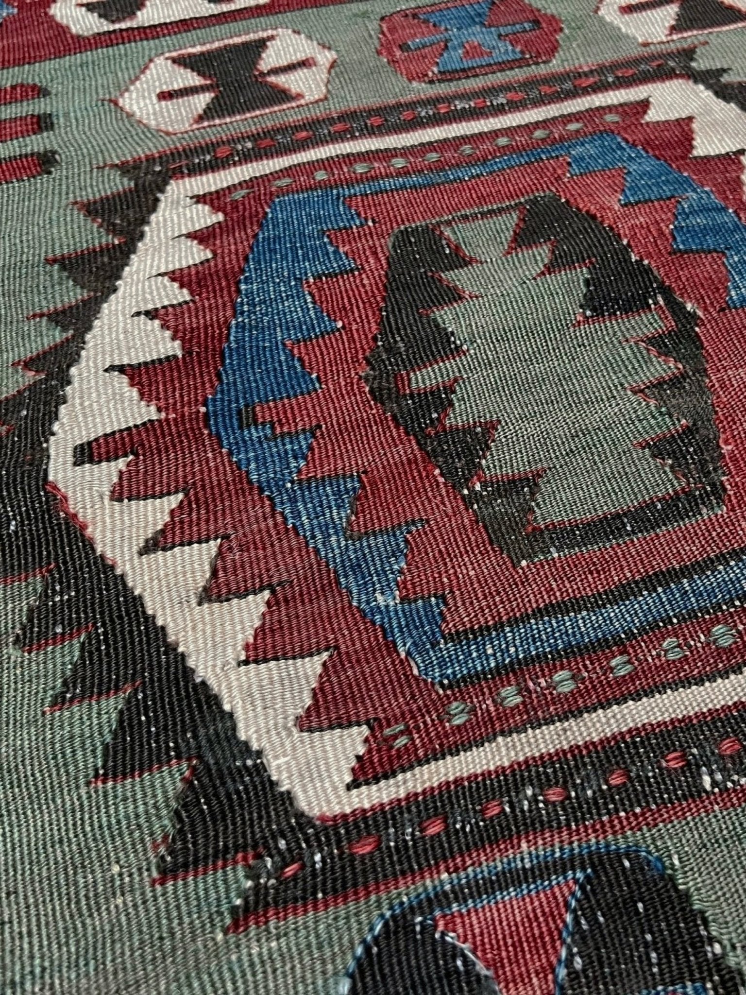 Close-up of a patterned rug with geometric design. Antique konya turkish kilim rug 6x9 vintage tribal geometric flatweave 1930s distressed handmade anatolian wool rug san francisco bay area rug shop indigo rugs