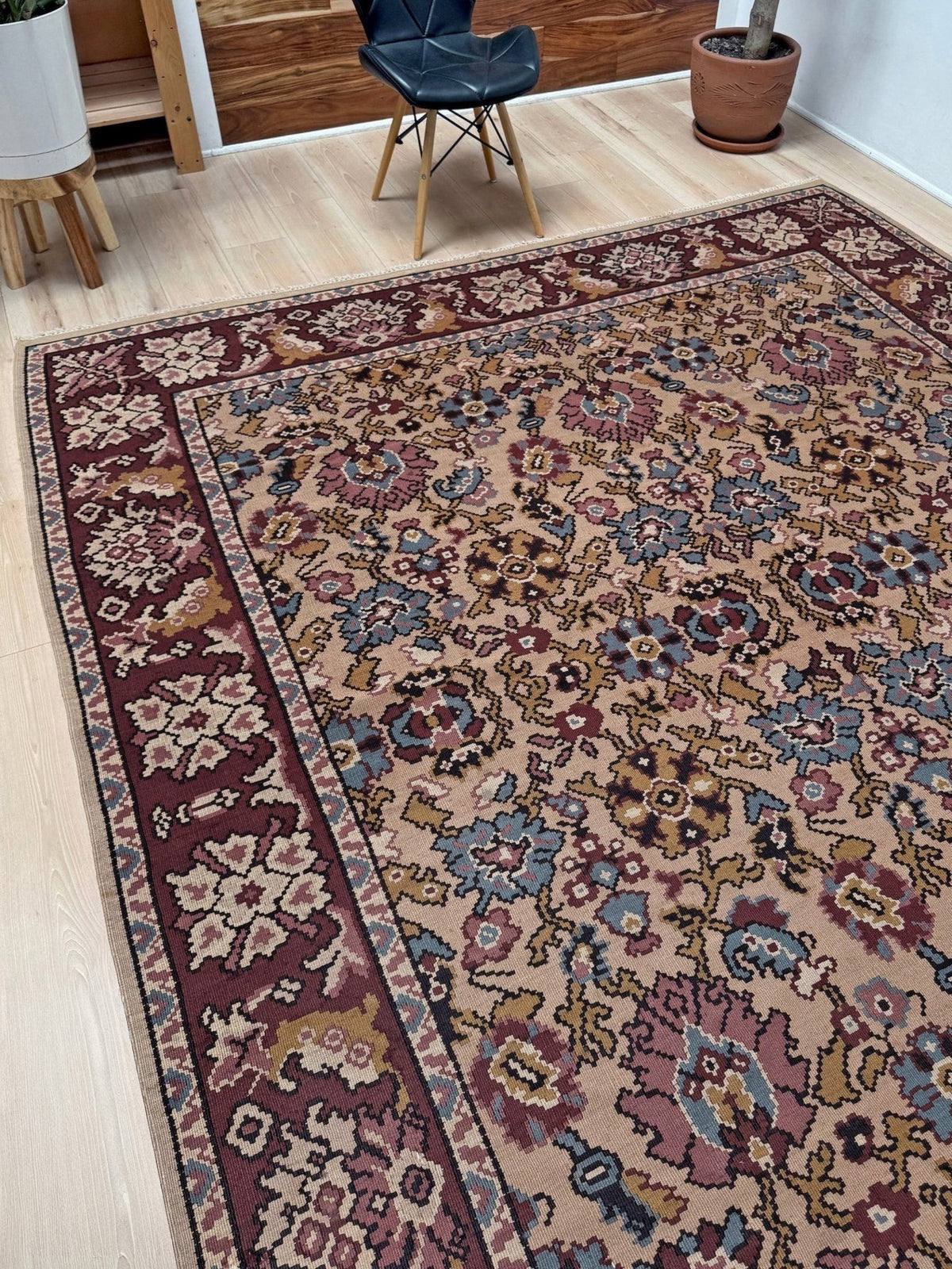 Handmade vintage Balkan floral kilim rug, 8x10, with warm parchment beige field and vine-and-blossom design in dusty blue, rose, olive, and burgundy tones.