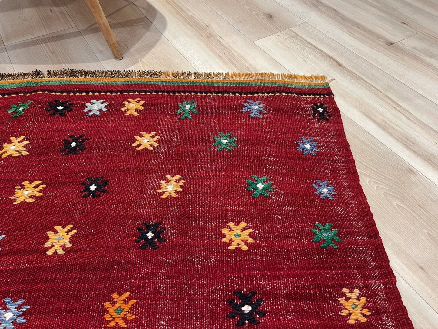 Vintage Turkish kilim rug from the Çanakkale region, handwoven wool flatweave measuring 5x7, featuring a rich brick red field with scattered geometric motifs. Authentic Anatolian tribal kilim with minimalist pattern, lightweight flat weave construction, ideal for living room, dining room, bedroom, or layered bohemian and eclectic interiors. Handmade vintage rug from Indigo Rugs, Burlingame, San Francisco Bay Area.