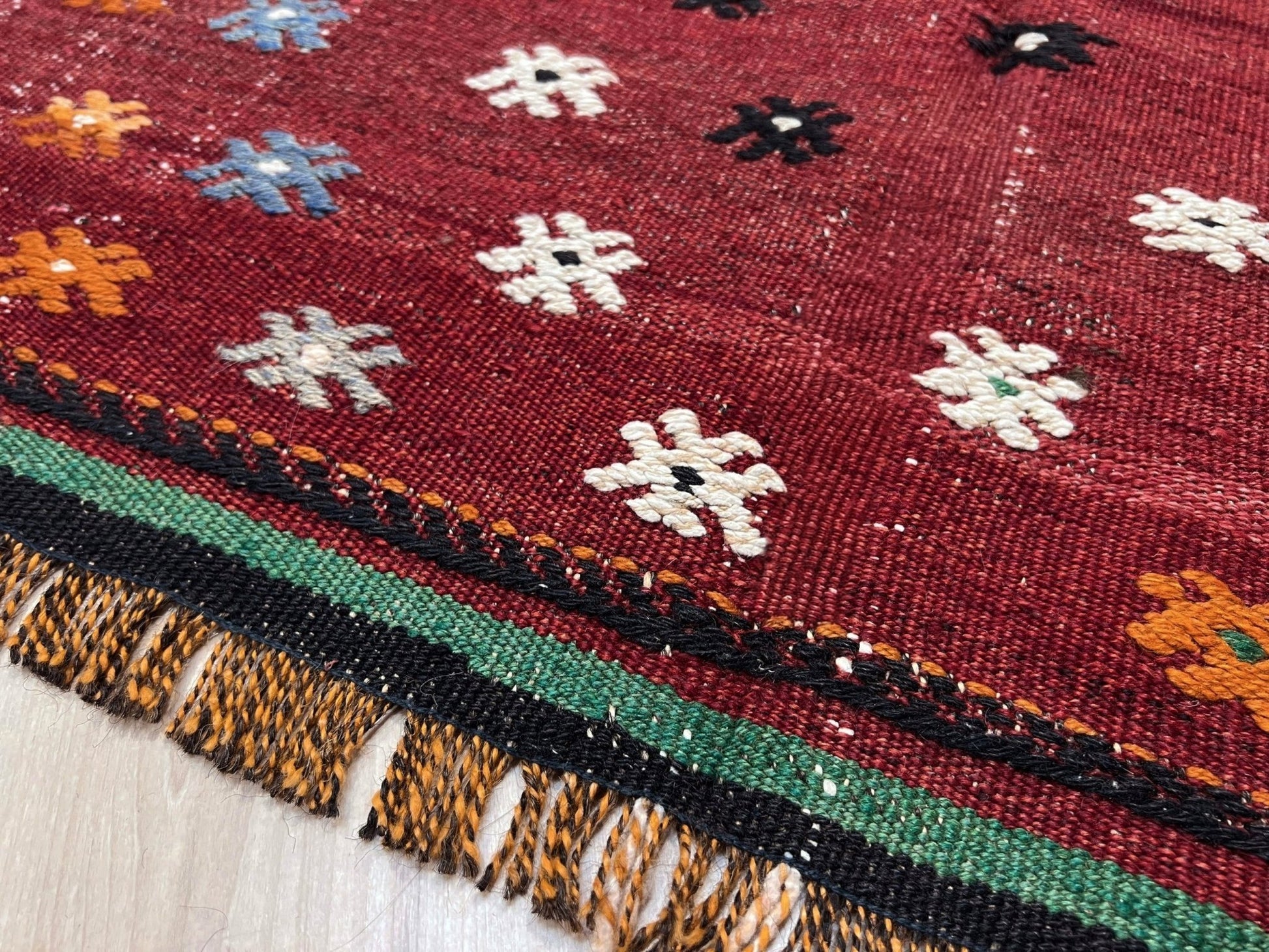 Vintage Turkish kilim rug from the Çanakkale region, handwoven wool flatweave measuring 5x7, featuring a rich brick red field with scattered geometric motifs. Authentic Anatolian tribal kilim with minimalist pattern, lightweight flat weave construction, ideal for living room, dining room, bedroom, or layered bohemian and eclectic interiors. Handmade vintage rug from Indigo Rugs, Burlingame, San Francisco Bay Area.