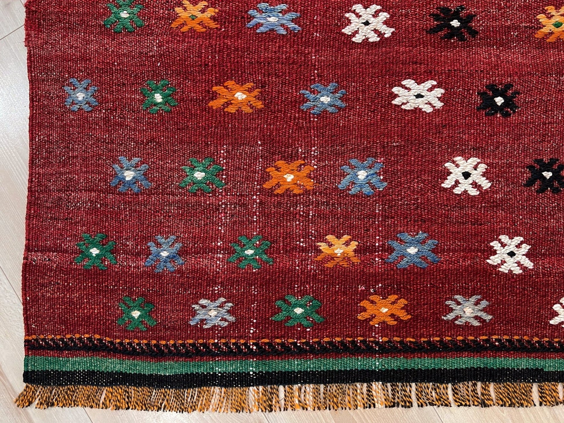 Vintage Turkish kilim rug from the Çanakkale region, handwoven wool flatweave measuring 5x7, featuring a rich brick red field with scattered geometric motifs. Authentic Anatolian tribal kilim with minimalist pattern, lightweight flat weave construction, ideal for living room, dining room, bedroom, or layered bohemian and eclectic interiors. Handmade vintage rug from Indigo Rugs, Burlingame, San Francisco Bay Area.