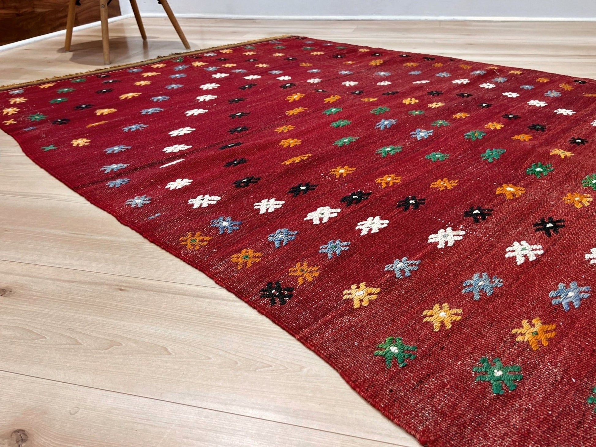 Vintage Turkish kilim rug from the Çanakkale region, handwoven wool flatweave measuring 5x7, featuring a rich brick red field with scattered geometric motifs. Authentic Anatolian tribal kilim with minimalist pattern, lightweight flat weave construction, ideal for living room, dining room, bedroom, or layered bohemian and eclectic interiors. Handmade vintage rug from Indigo Rugs, Burlingame, San Francisco Bay Area.