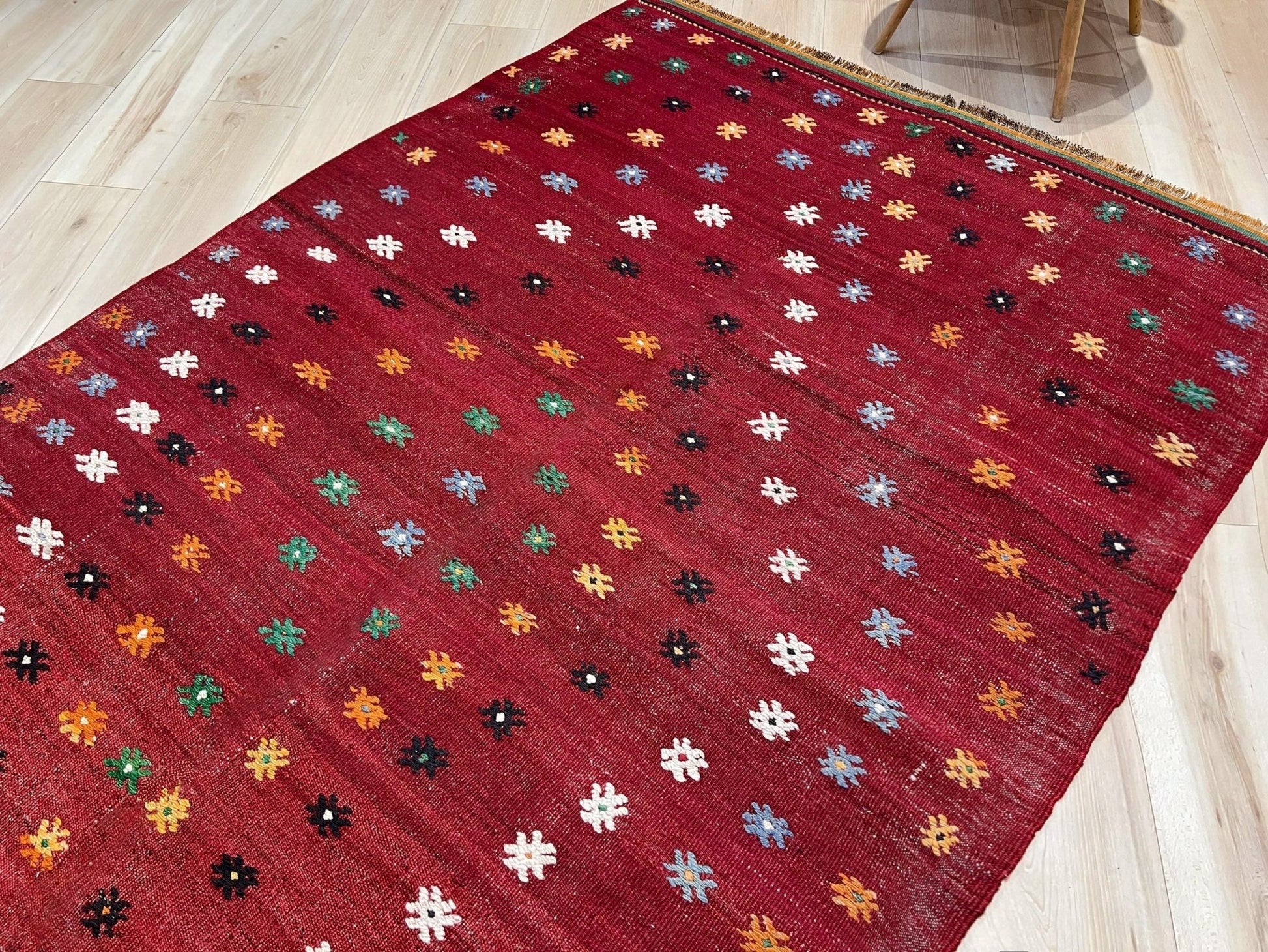 Vintage Turkish kilim rug from the Çanakkale region, handwoven wool flatweave measuring 5x7, featuring a rich brick red field with scattered geometric motifs. Authentic Anatolian tribal kilim with minimalist pattern, lightweight flat weave construction, ideal for living room, dining room, bedroom, or layered bohemian and eclectic interiors. Handmade vintage rug from Indigo Rugs, Burlingame, San Francisco Bay Area.