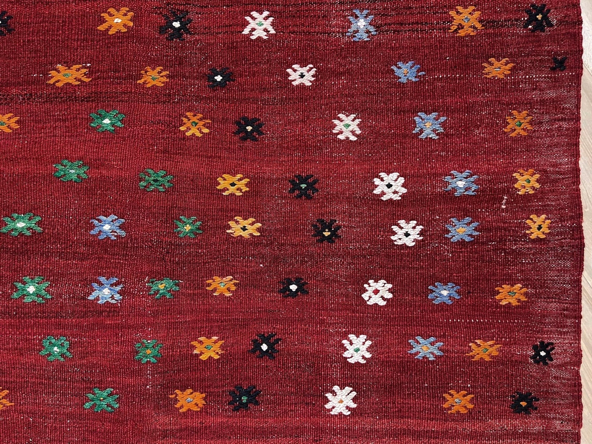 Vintage Turkish kilim rug from the Çanakkale region, handwoven wool flatweave measuring 5x7, featuring a rich brick red field with scattered geometric motifs. Authentic Anatolian tribal kilim with minimalist pattern, lightweight flat weave construction, ideal for living room, dining room, bedroom, or layered bohemian and eclectic interiors. Handmade vintage rug from Indigo Rugs, Burlingame, San Francisco Bay Area.