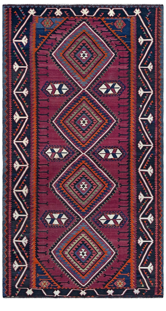 A rectangular area rug with a traditional geometric pattern, featuring three large central diamond motifs in magenta, navy, orange, and cream, surrounded by a dark navy border.