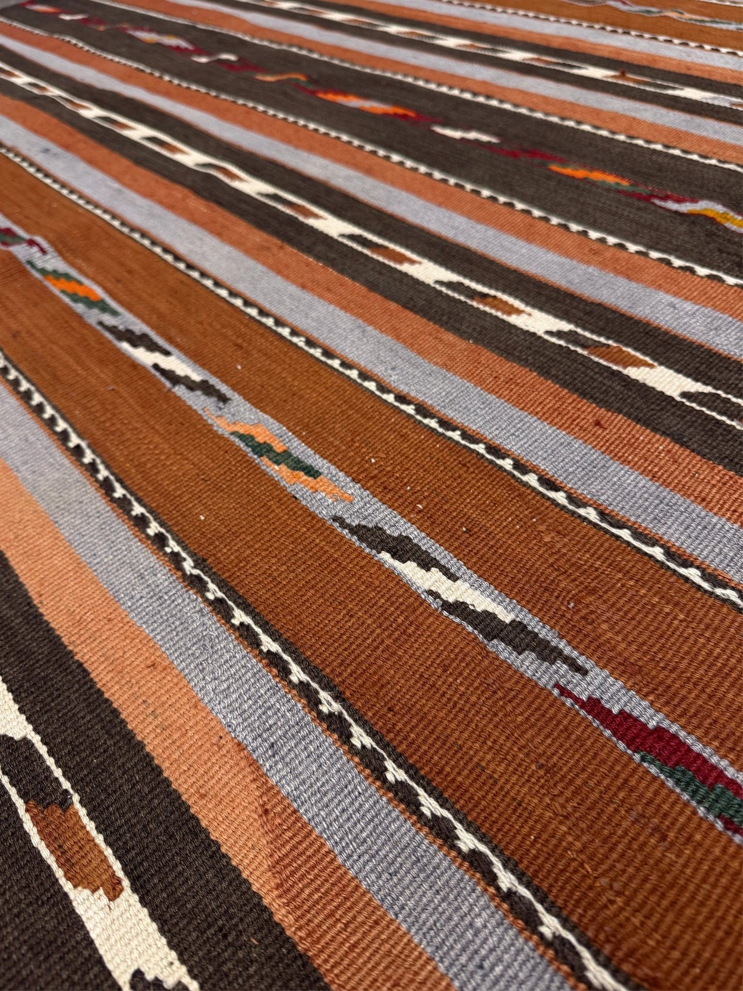 Close-up of a patterned fabric with brown, beige, and gray stripes. Vintage Caucasian kilim rug with horizontal tribal stripes in rust, brown, gray, and ivory tones, handwoven wool flatweave rug 6x9
