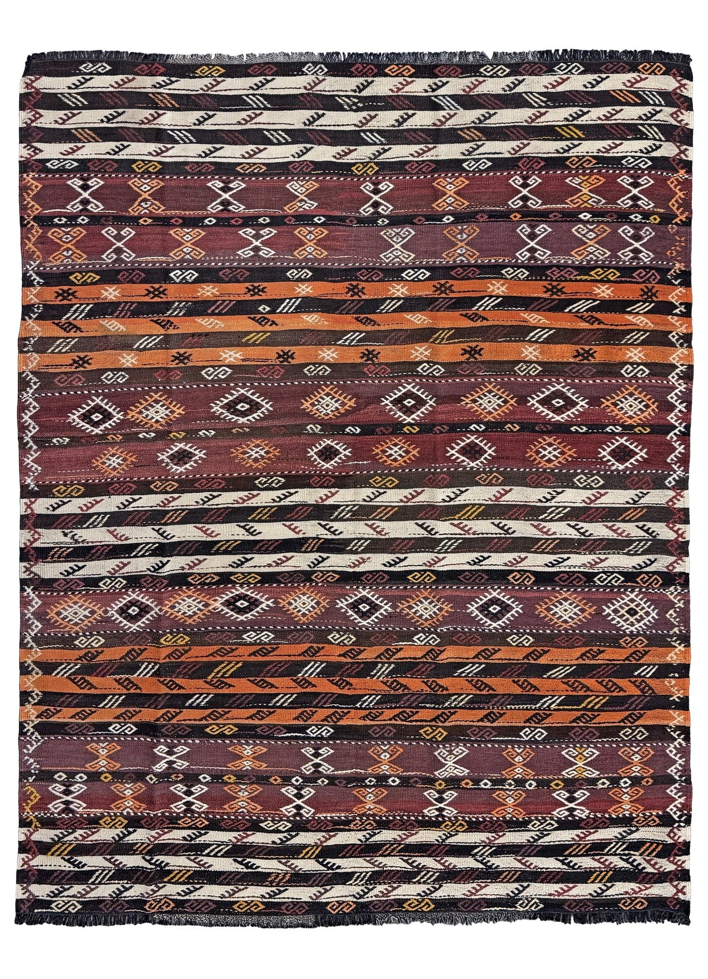 Patterned fabric with tribal design in brown, black, and white. Vintage Kars kilim rug from Eastern Turkey, 5'11" x 7'8", with horizontal tribal bands in brown, ivory, rust, and charcoal geometric motifs.