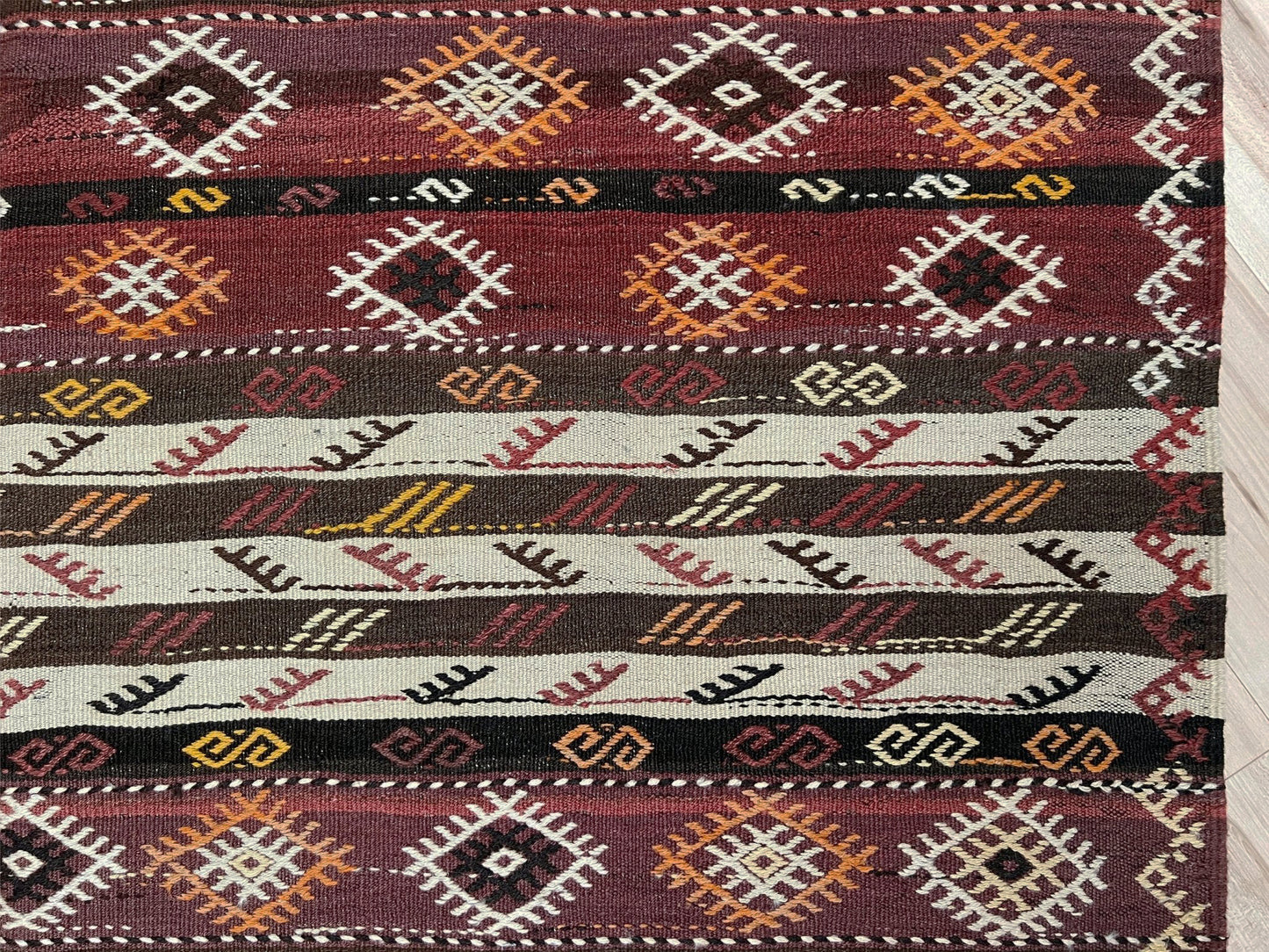 Patterned rug with geometric design on a plain background. Vintage Kars kilim rug from Eastern Turkey, 6x8, with horizontal tribal bands in brown, ivory, rust, and charcoal geometric motifs.