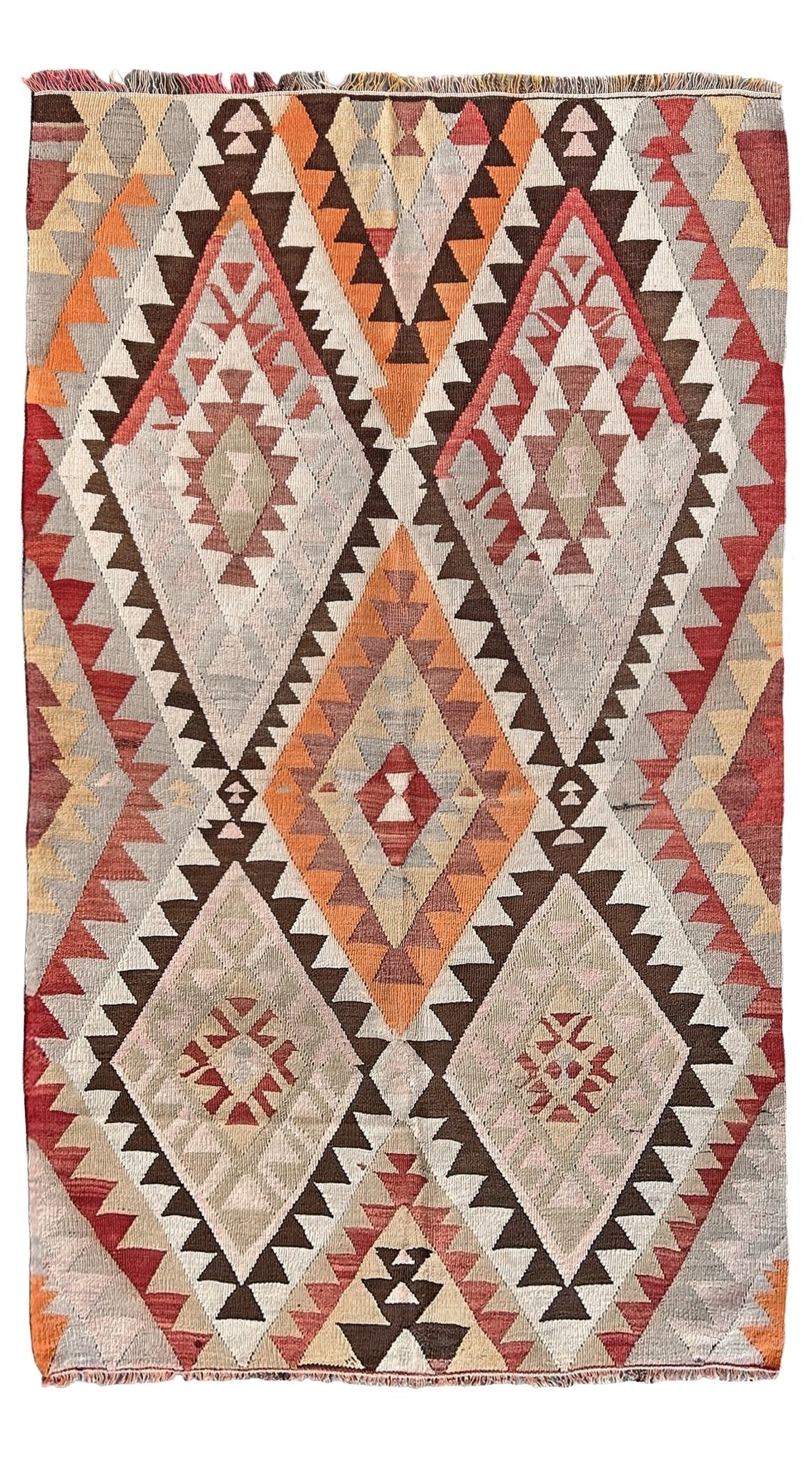 Woven rug with geometric diamond pattern in earthy tones on a white background. Vintage Mut region Turkish kilim, 4x 7, with large stepped diamond medallions and tribal geometric motifs in faded earthy tones handwoven wool flatweave from the 1960s.
