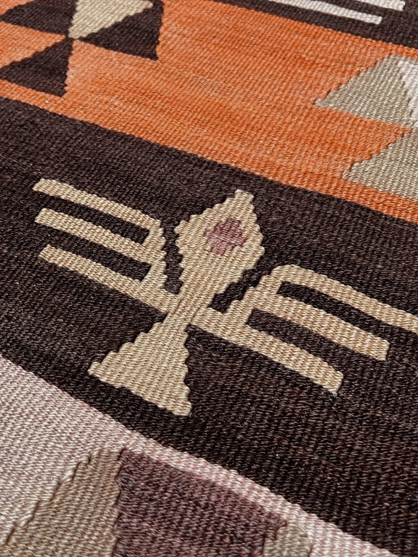Close-up of a patterned rug with geometric design. Vintage Central Anatolian Turkish kilim rug, 6x8 with horizontal tribal bands and geometric motifs. 