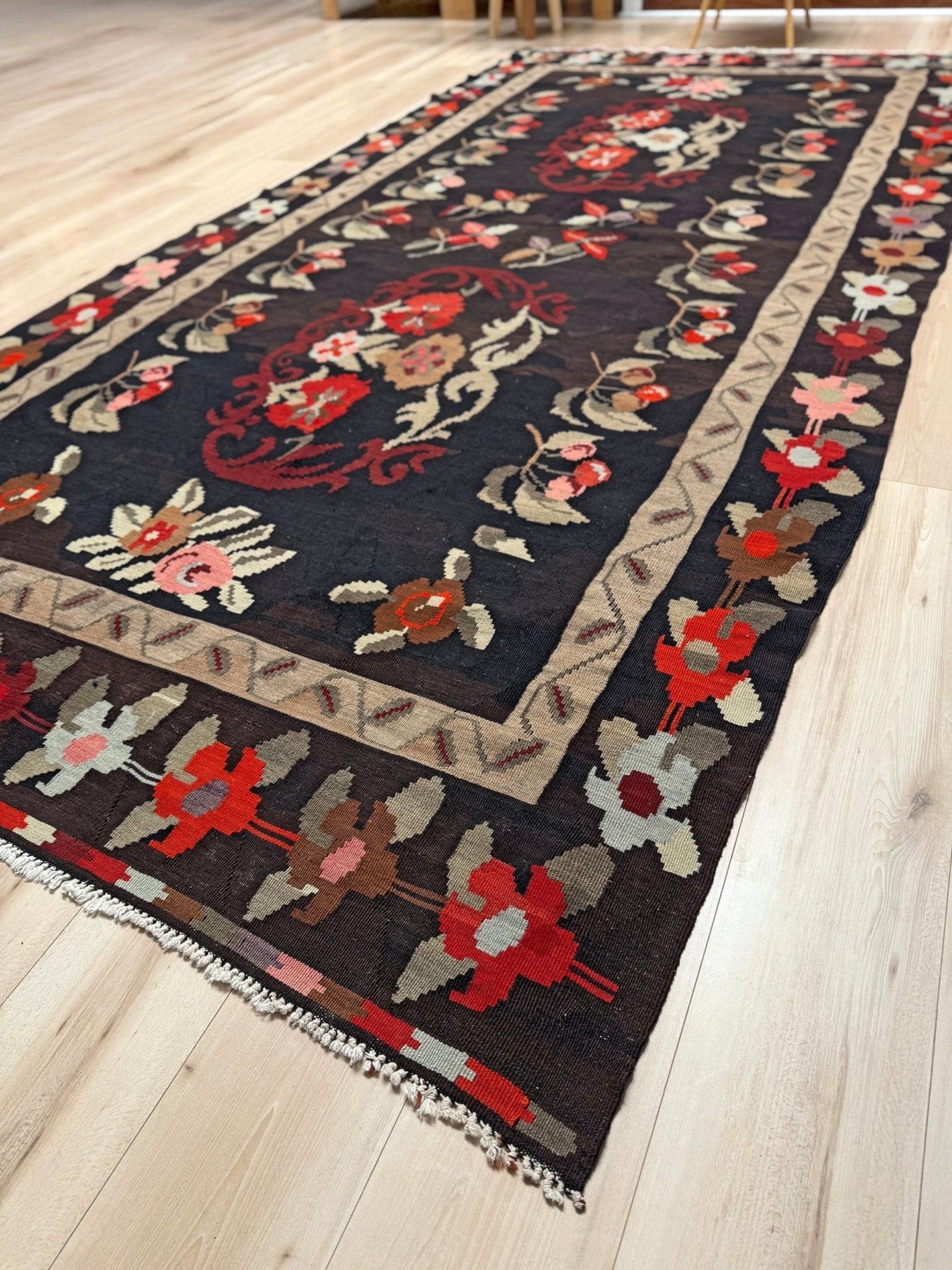 Handmade vintage Karabagh kilim wide runner rug, approx. 6x12, with dark chocolate brown field and large floral motifs in crimson, rose, ivory, and olive tones.
