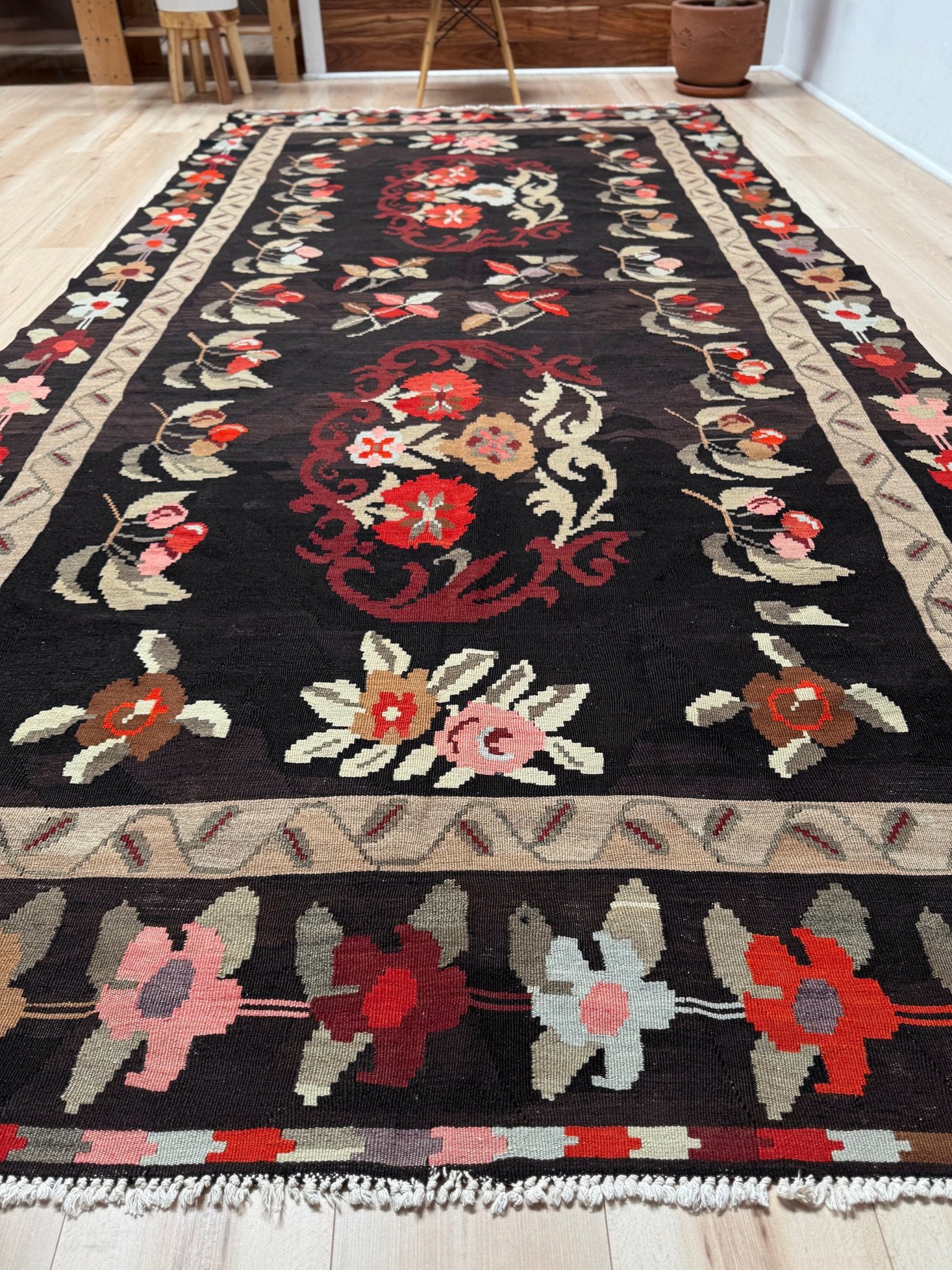 Handmade vintage Karabagh kilim wide runner rug, approx. 6x12, with dark chocolate brown field and large floral motifs in crimson, rose, ivory, and olive tones.