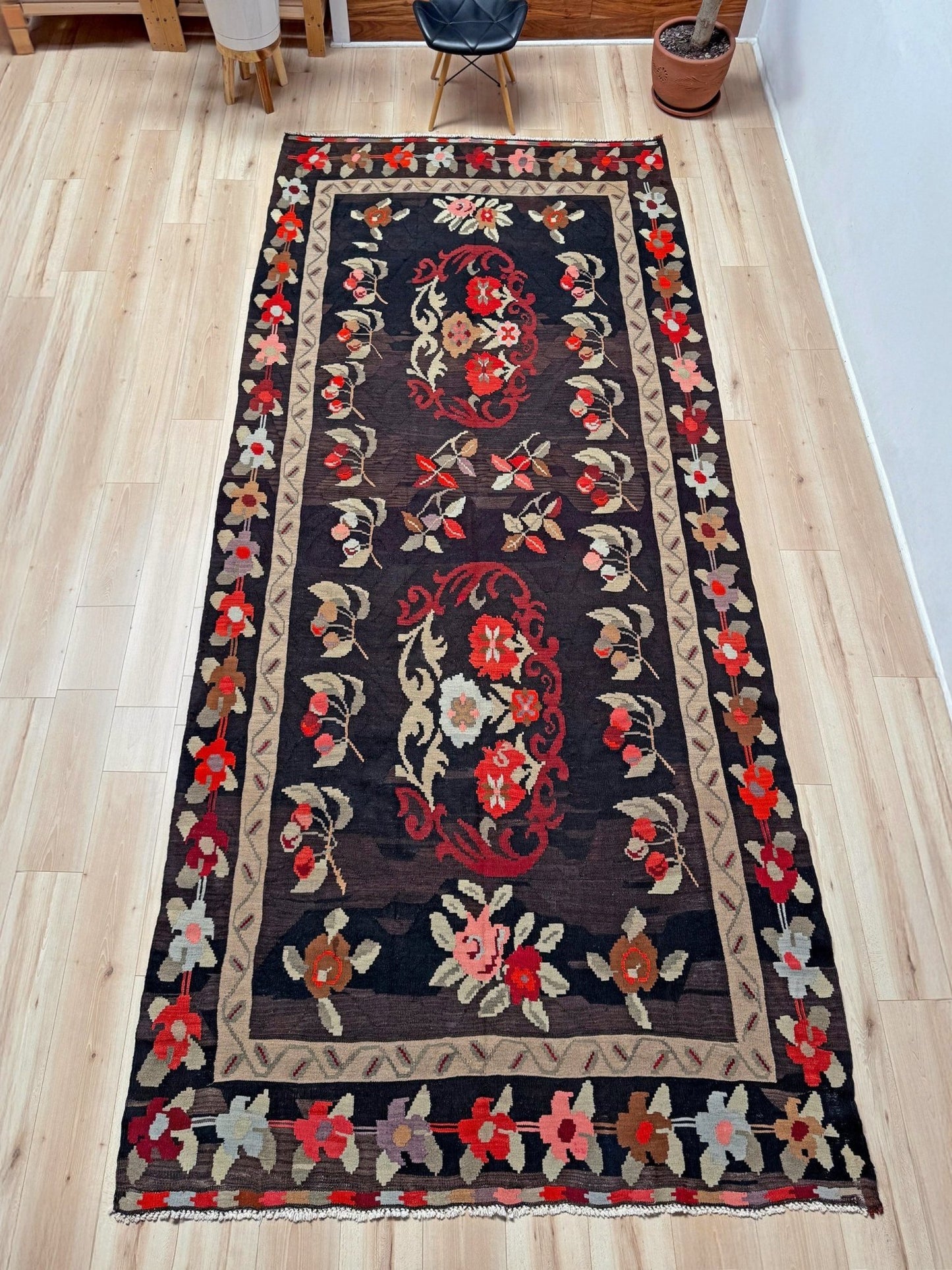 Handmade vintage Karabagh kilim wide runner rug, approx. 6x12, with dark chocolate brown field and large floral motifs in crimson, rose, ivory, and olive tones.
