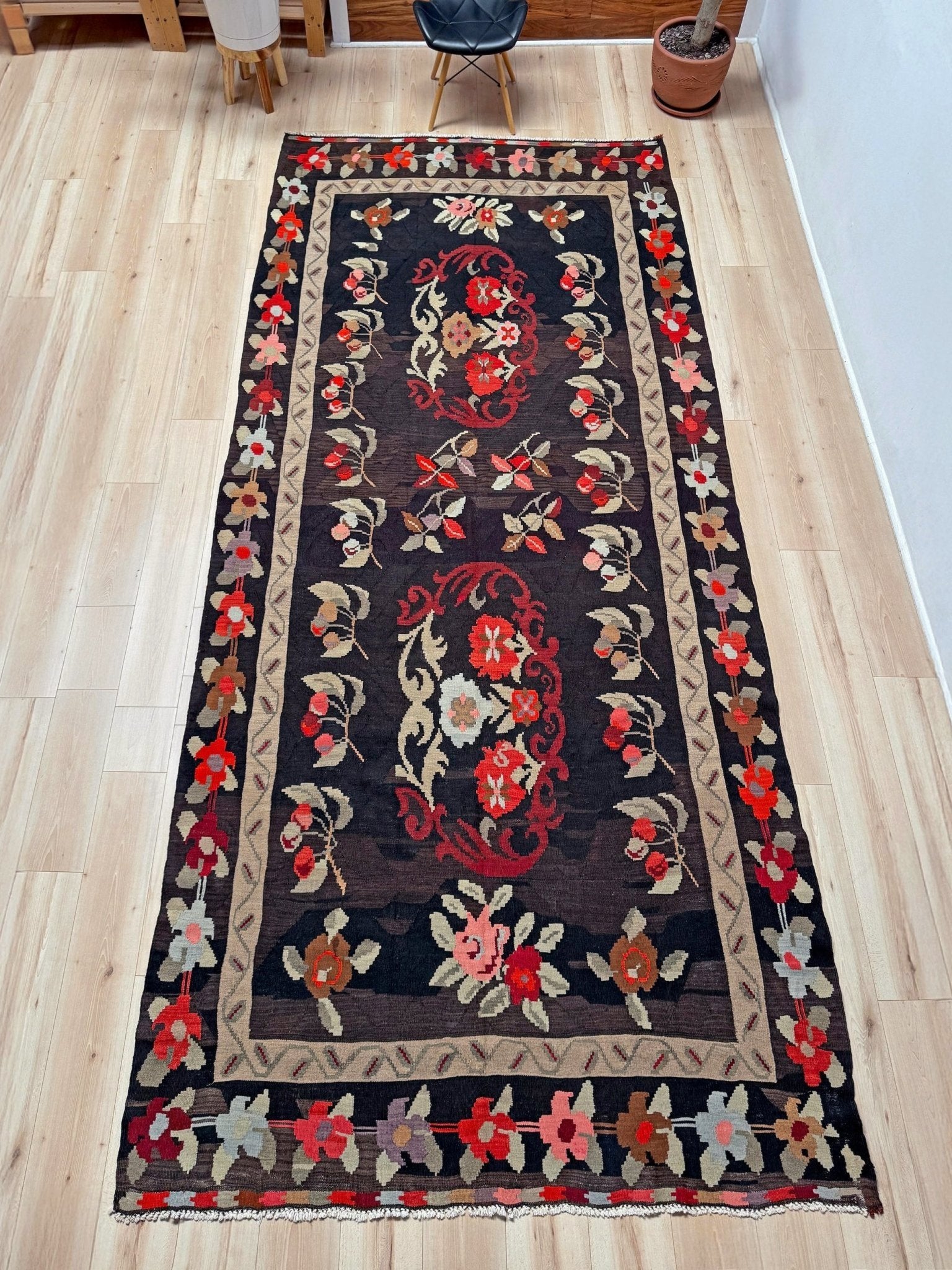 Handmade vintage Karabagh kilim wide runner rug, approx. 6x12, with dark chocolate brown field and large floral motifs in crimson, rose, ivory, and olive tones.