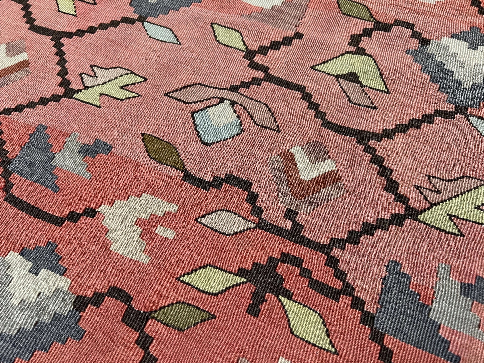 Vintage Balkan Pirot Sharkoy kilim rug, 5x8 with faded geometric floral motifs in dusty coral pink, ivory, sage, and soft blue tones with natural abrash.