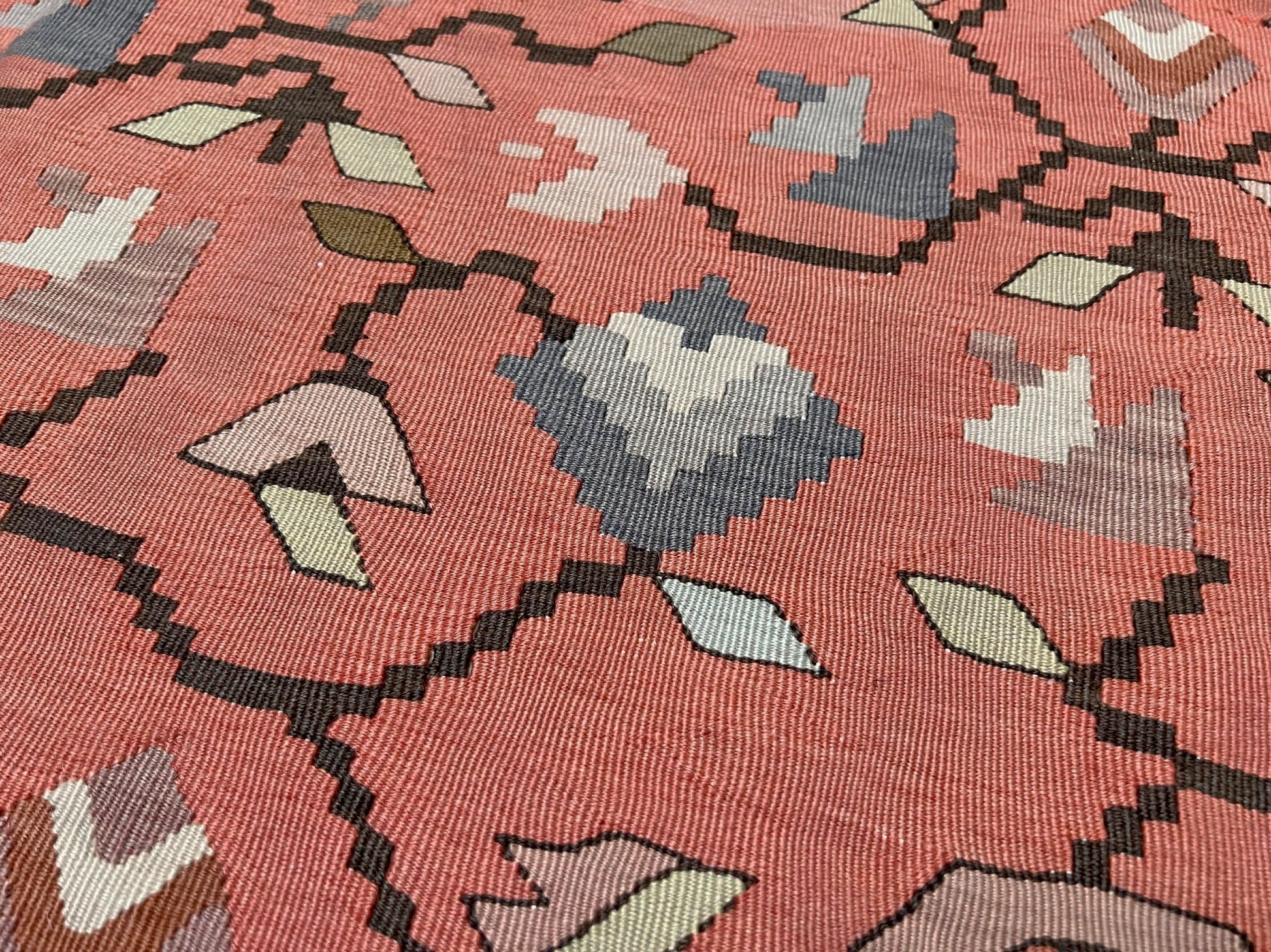 Vintage Balkan Pirot Sharkoy kilim rug, 5x8 with faded geometric floral motifs in dusty coral pink, ivory, sage, and soft blue tones with natural abrash.