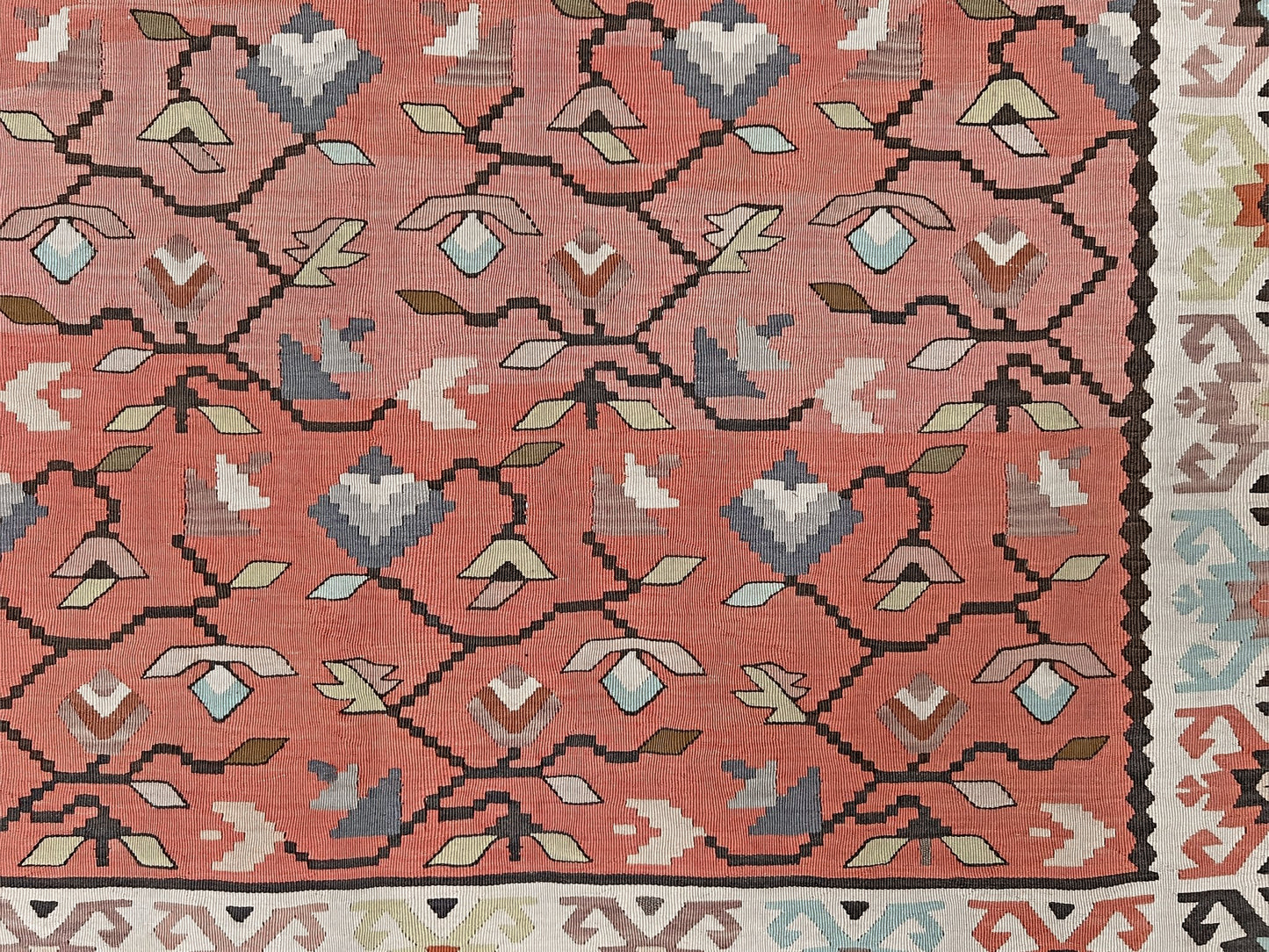 Vintage Balkan Pirot Sharkoy kilim rug, 5x8 with faded geometric floral motifs in dusty coral pink, ivory, sage, and soft blue tones with natural abrash.