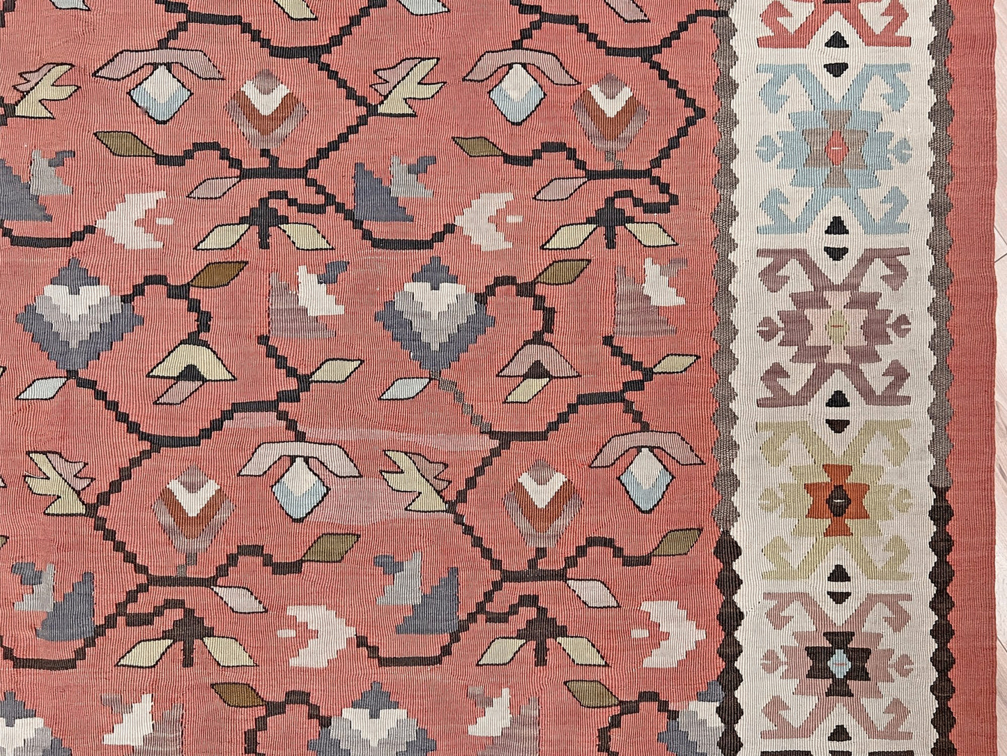 Vintage Balkan Pirot Sharkoy kilim rug, 5x8 with faded geometric floral motifs in dusty coral pink, ivory, sage, and soft blue tones with natural abrash.