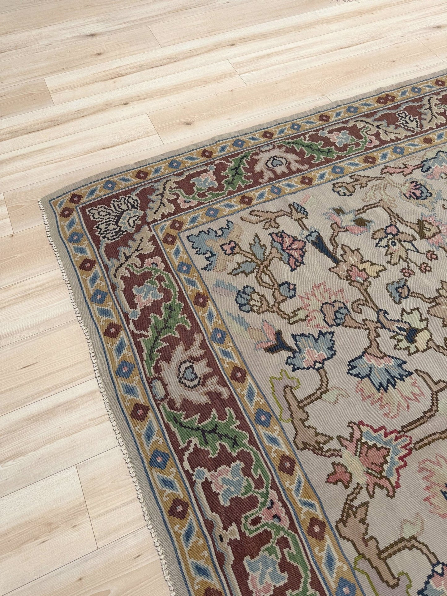 Handmade square 8x9 vintage Balkan floral kilim flatweave rug with light parchment field and vine-and-blossom design in dusty blue, rose, and sage tones.