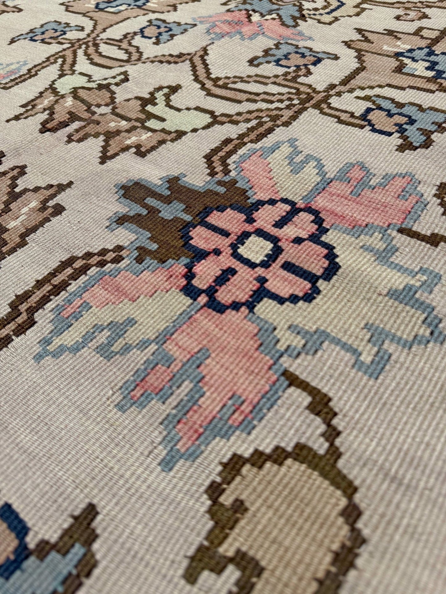 Close-up of a floral patterned rug with pink flowers and intricate designs.