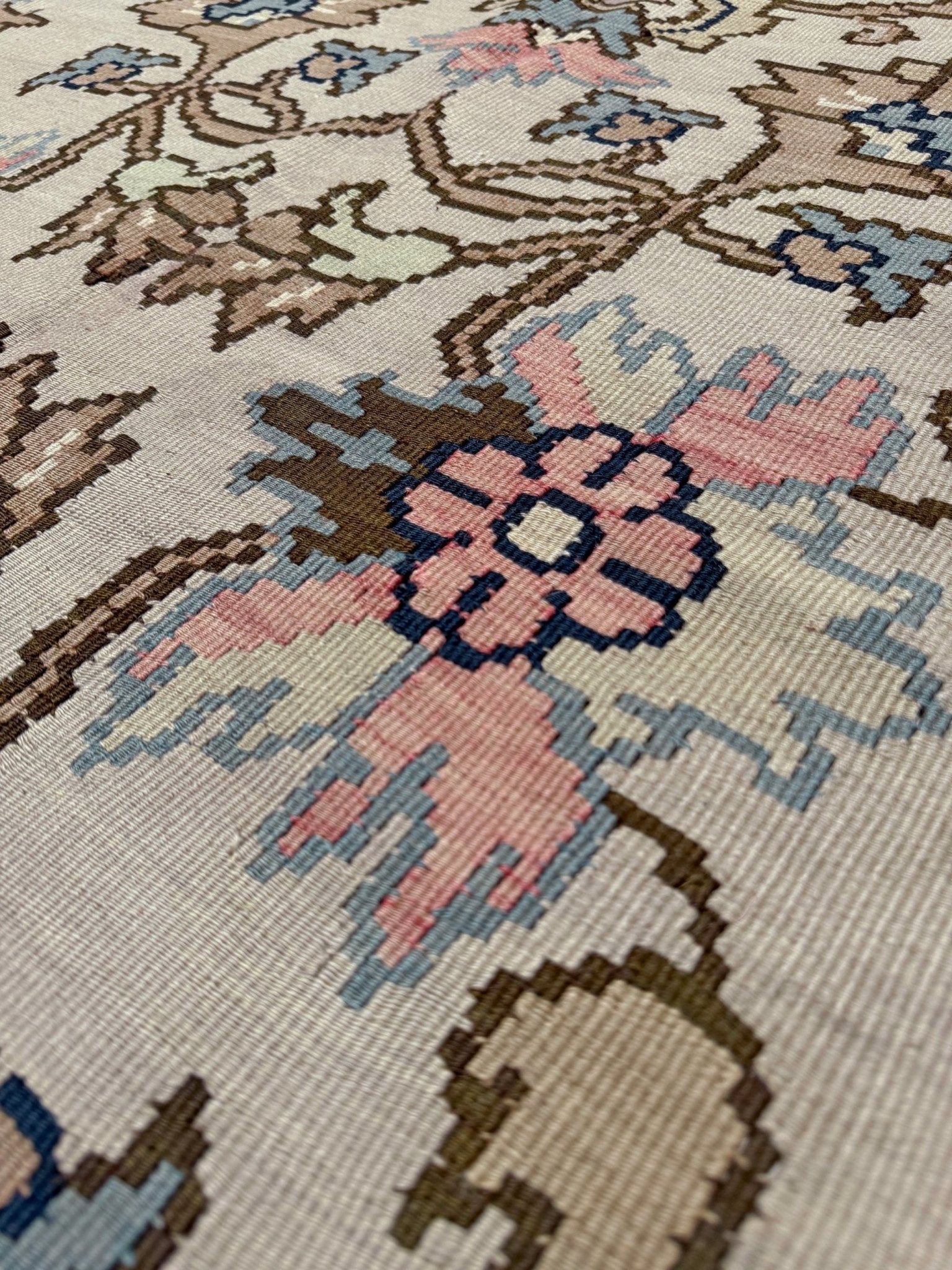 Close-up of a floral patterned rug with pink flowers and intricate designs.