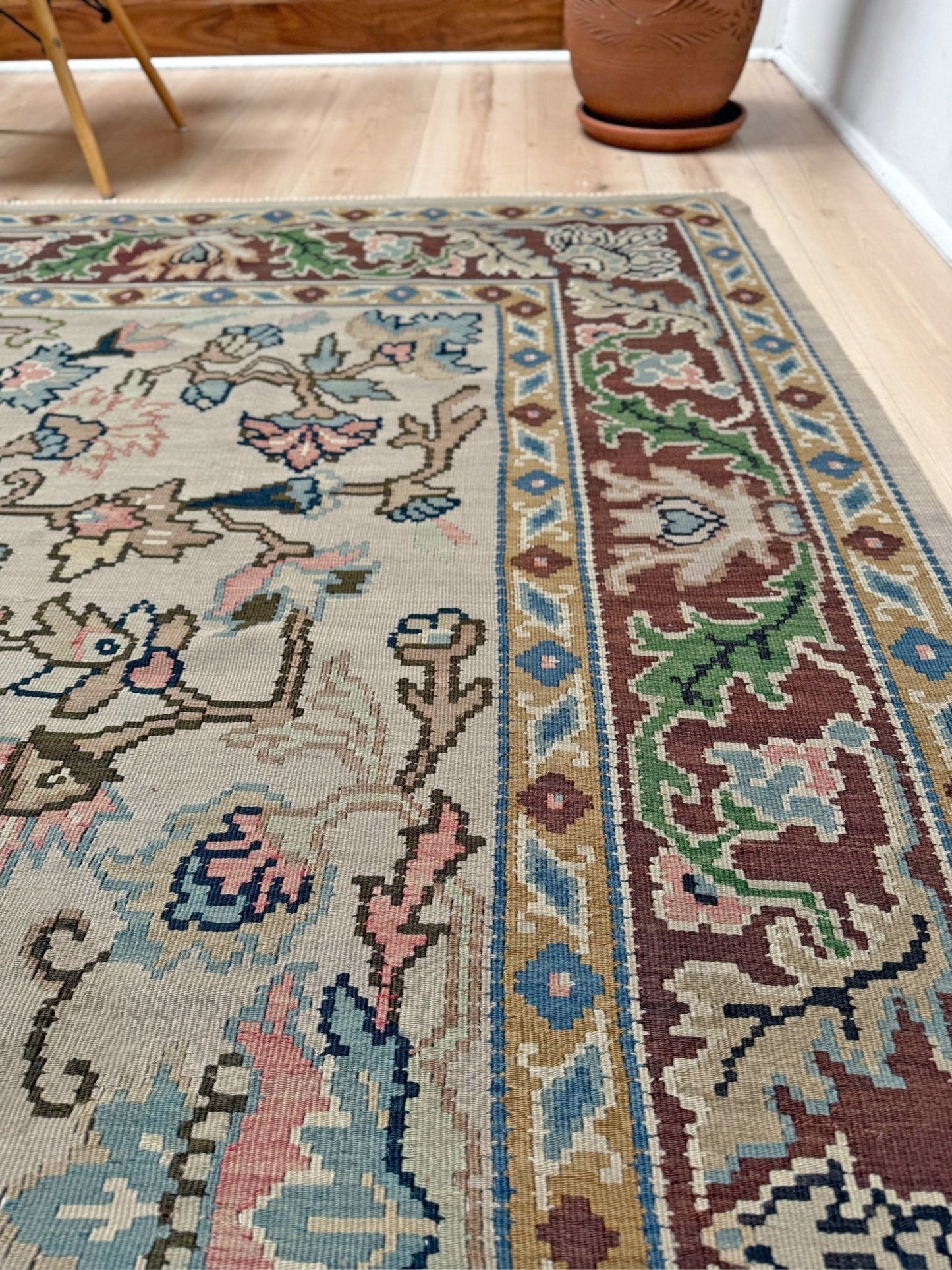 Handmade square 8x9 vintage Balkan floral kilim flatweave rug with light parchment field and vine-and-blossom design in dusty blue, rose, and sage tones.