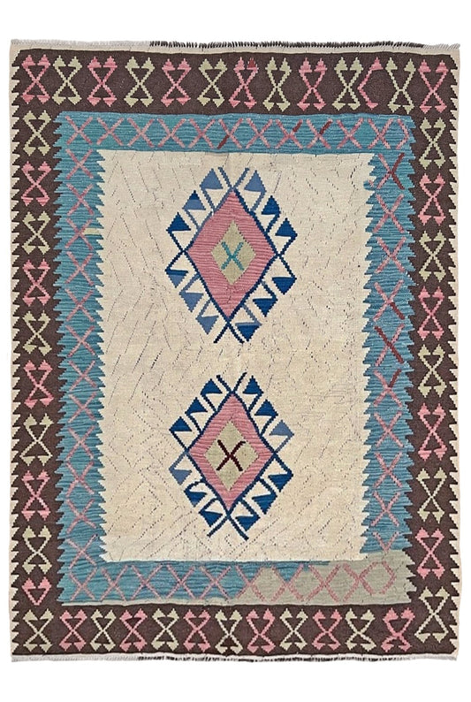 Decorative rug with geometric pattern featuring diamonds and cross symbols on a white background. Vintage Turkish kilim rug, 5x7, with ivory field, pink and blue tribal medallions, and geometric borders in brown and sage tones.
