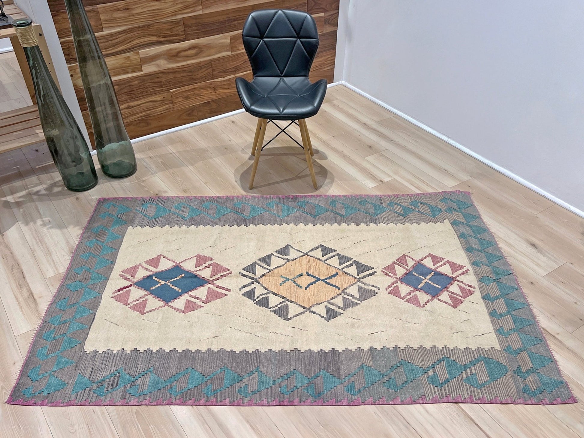 Decorative rug with geometric pattern featuring diamonds and cross symbols on a white background. Vintage Turkish kilim rug, 5x7. 