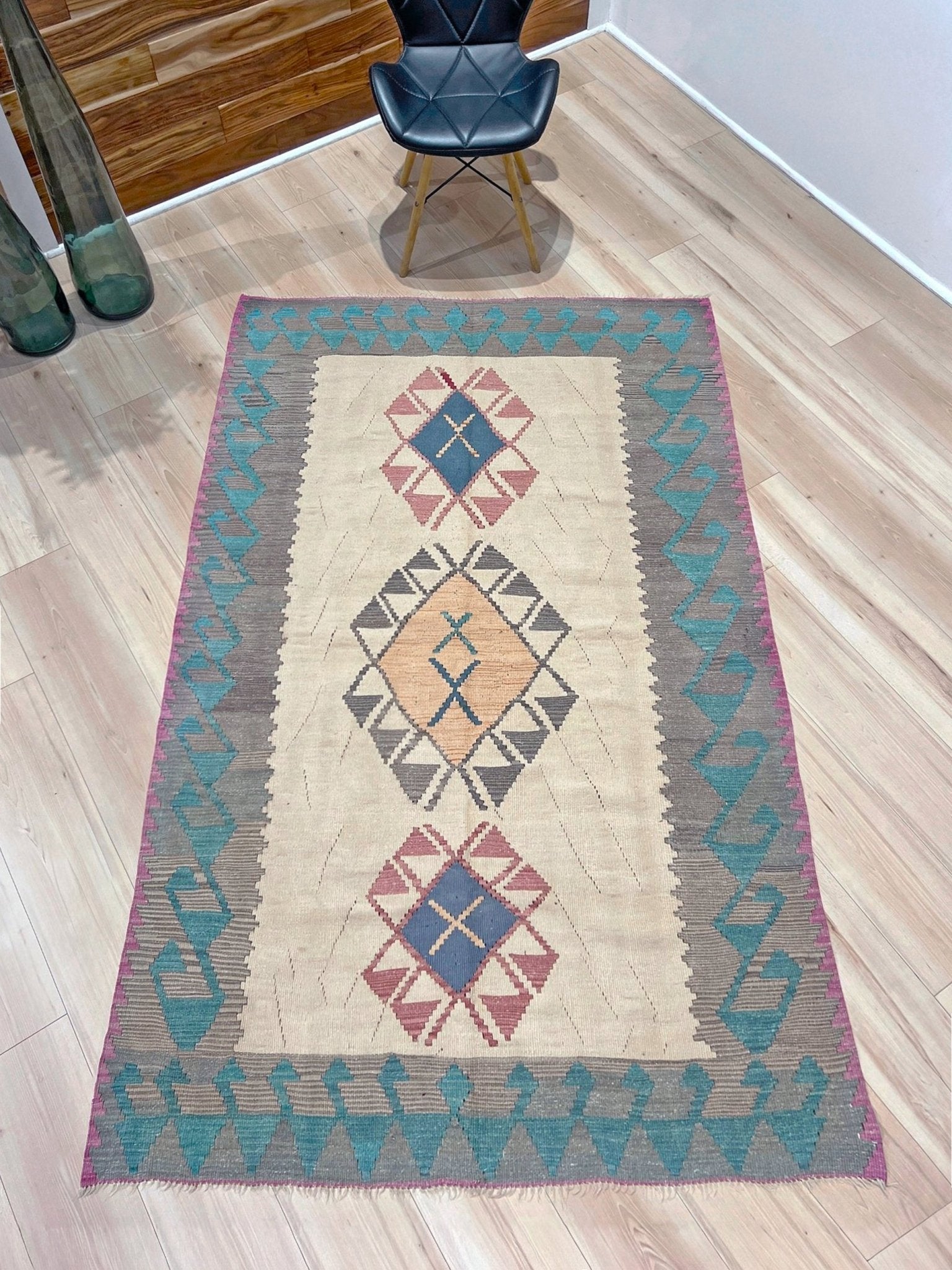 Decorative rug with geometric pattern featuring diamonds and cross symbols on a white background. Vintage Turkish kilim rug, 5x7. 