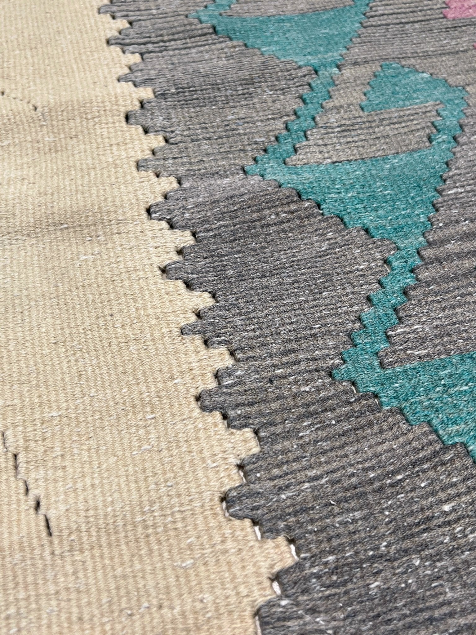 Decorative rug with geometric pattern featuring diamonds and cross symbols on a white background. Vintage Turkish kilim rug, 5x7. 