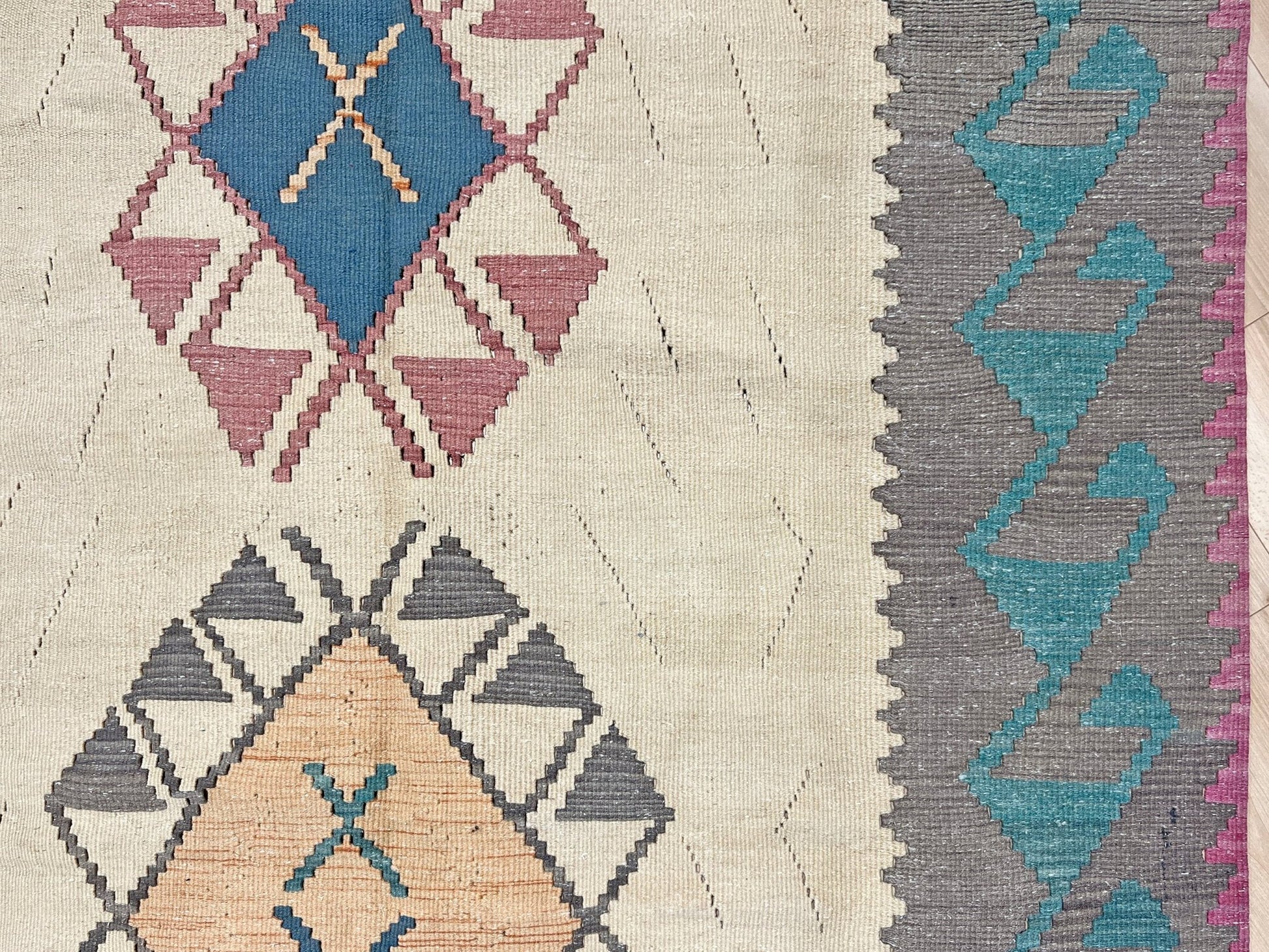 Decorative rug with geometric pattern featuring diamonds and cross symbols on a white background. Vintage Turkish kilim rug, 5x7. 