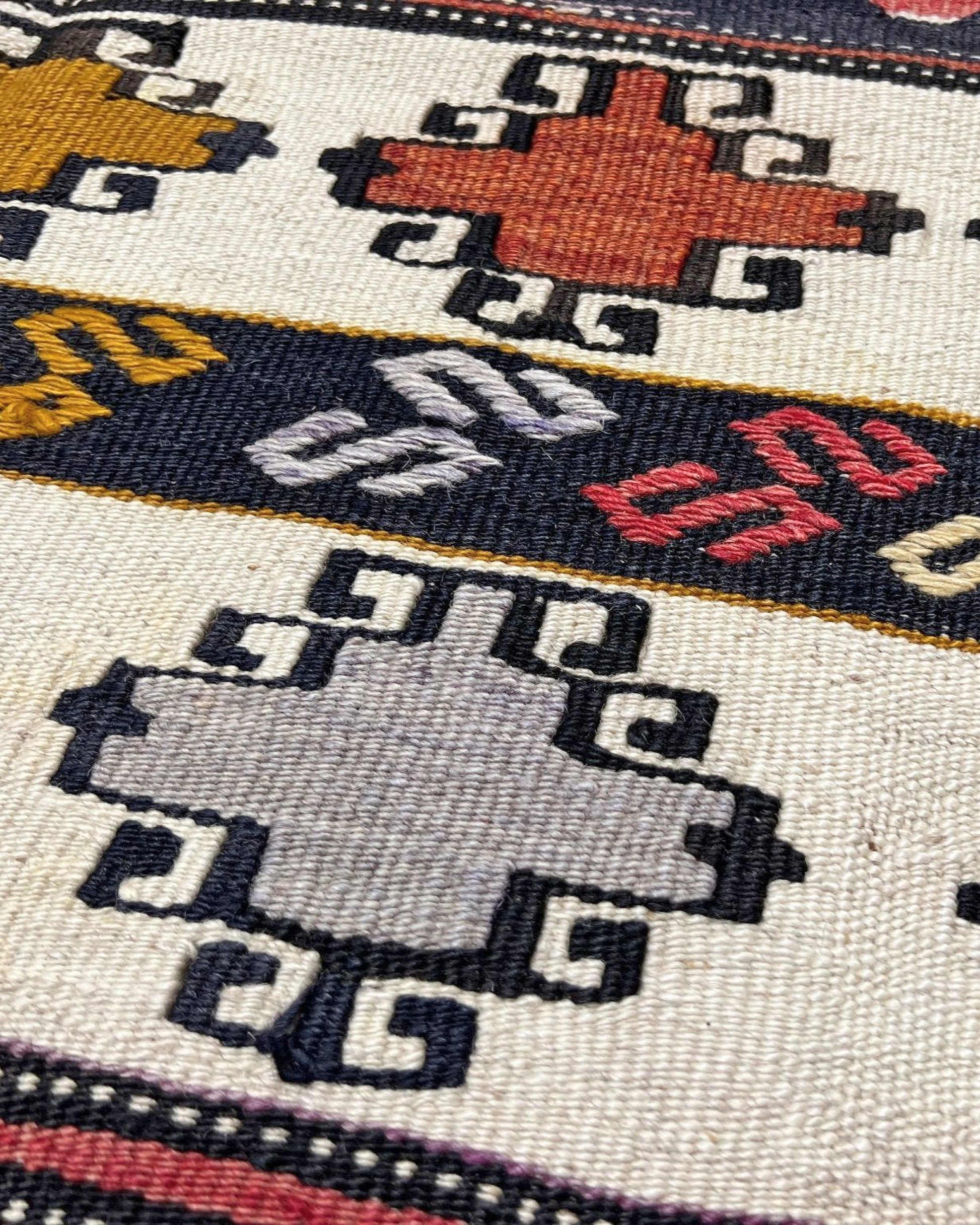 Close-up of a woven textile with geometric patterns in various colors on a white background. 6x8 Vintage Karakecili Turkish kilim rug with bold tribal geometric motifs in charcoal, coral red, ivory, mustard, and soft gray, handwoven flatweave from the 1950s. 