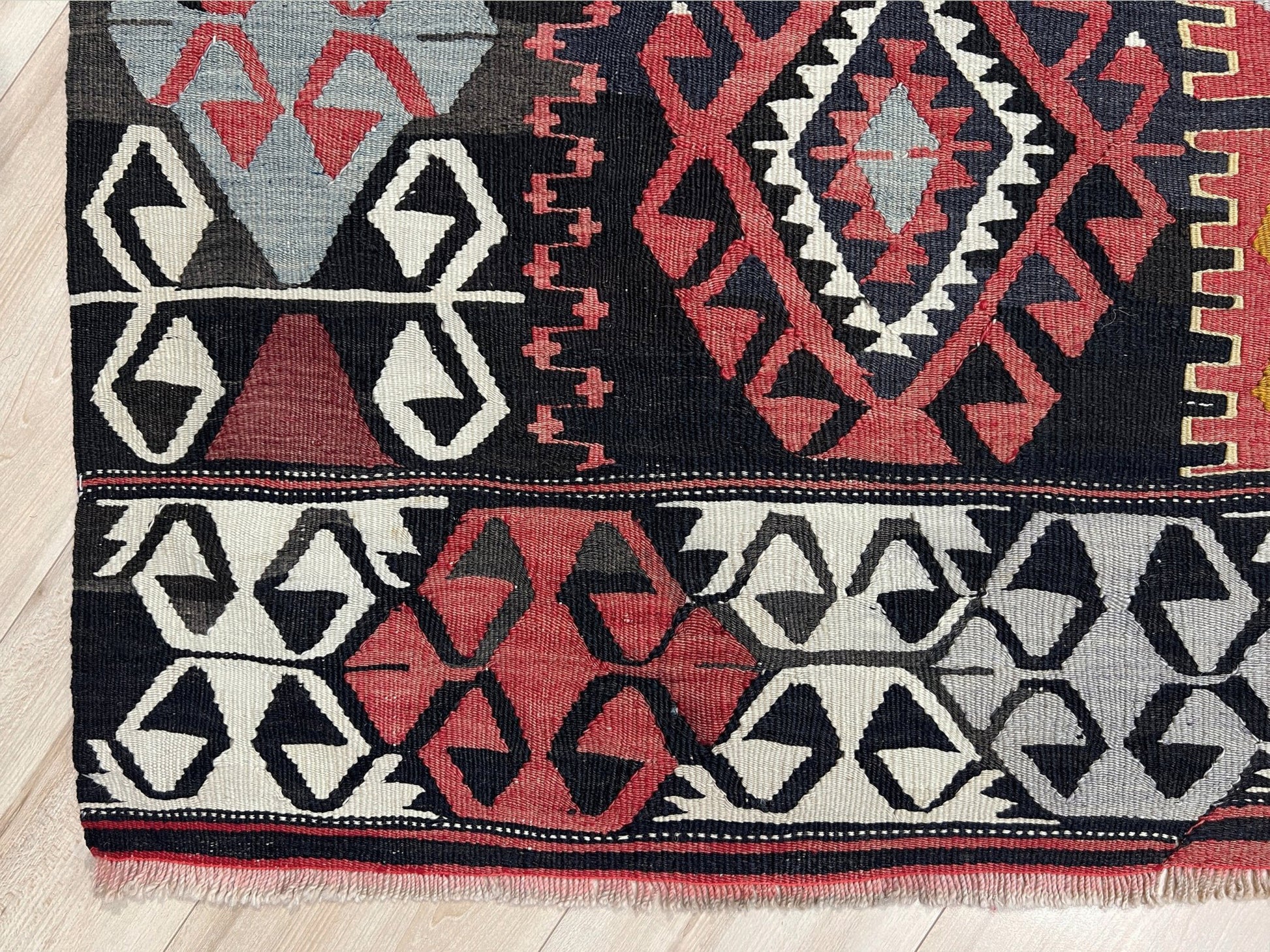 6x8 Vintage Karakecili Turkish kilim rug with bold tribal geometric motifs in charcoal, coral red, ivory, mustard, and soft gray, handwoven flatweave from the 1950s. 