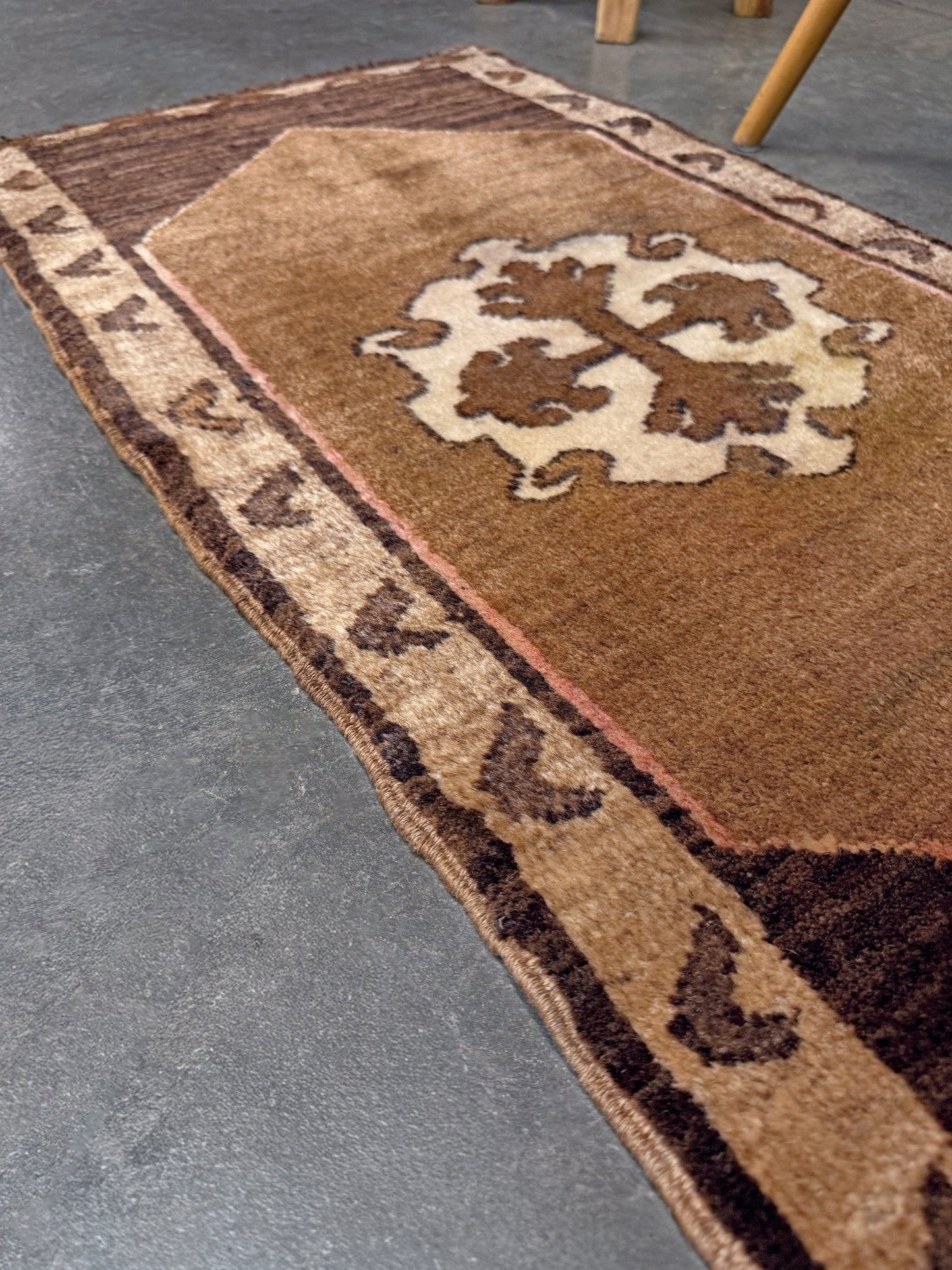 Decorative neutral vintage Turkish mini rug yastik 2x3 made from undyed handspun sheep wool, featuring natural brown and ivory tones with a subtle red accent, geometric medallion design. From Indigo Rugs, Burlingame — the best rug shop in the San Francisco Bay Area. Free shipping.