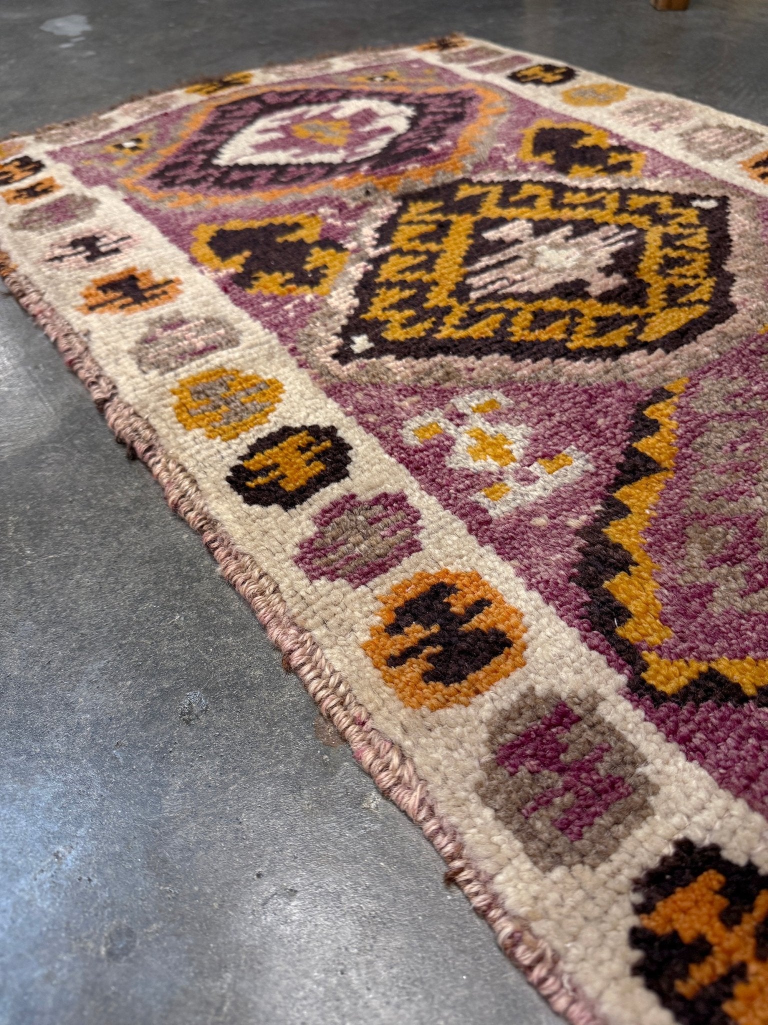 Vintage Turkish Yastik mini rug with earth colors mauve-purple, taupe, and burnt orange. Handmade wool, 2x3 feet. One-of-a-kind rug from Indigo Rugs, the best rug shop in the San Francisco Bay Area (Burlingame, CA). Free shipping included.
